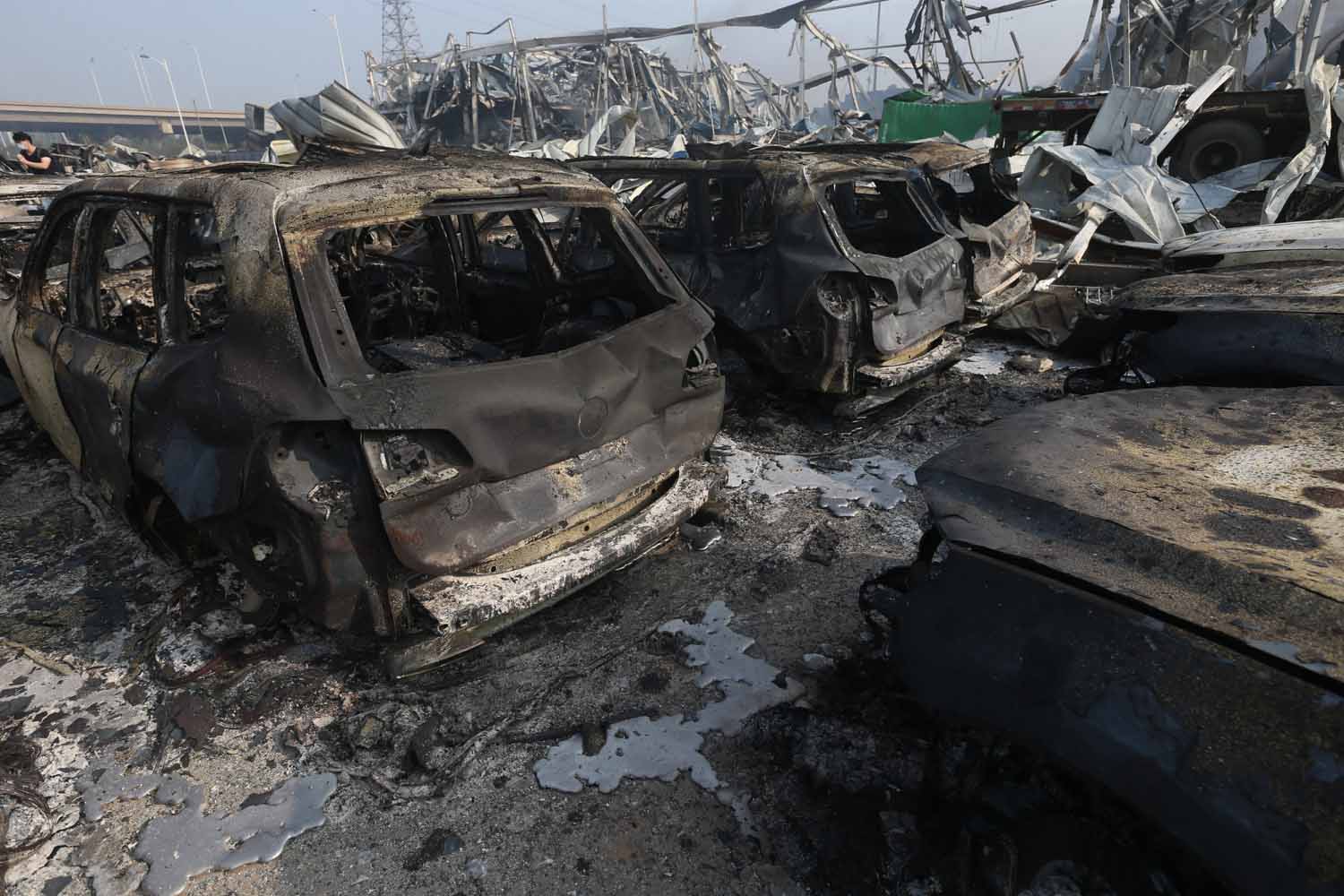 TIANJIN, CHINA - AUGUST 13: (CHINA OUT) Burnt cars are seen in the debris following the explosions of a warehouse in Binhai New Area on August 13, 2015 in Tianjin, China. At least 17 people dead, 32 are in critical condition and at least another 400 injured during the explosions of a warehouse on late Wednesday in Binhai New Area in Tianjin, according to police authority.  (Photo by ChinaFotoPress/ChinaFotoPress via Getty Images)