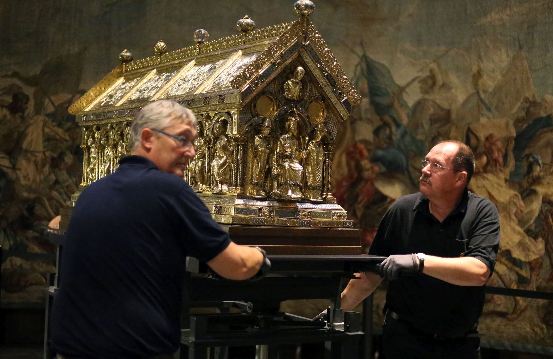 epa04856217 Employees of the Aachen diocese push the Shrine of Charlemagne at its new location at the Aachen Cathedral, in Aachen, Germany, 22 July 2015. The shrine has been moved from the choir hall back to its original position in the central structure of the cathedral. Charles the Great became the first Holy Roman Emperor in 800 AD.  EPA/OLIVER BERG