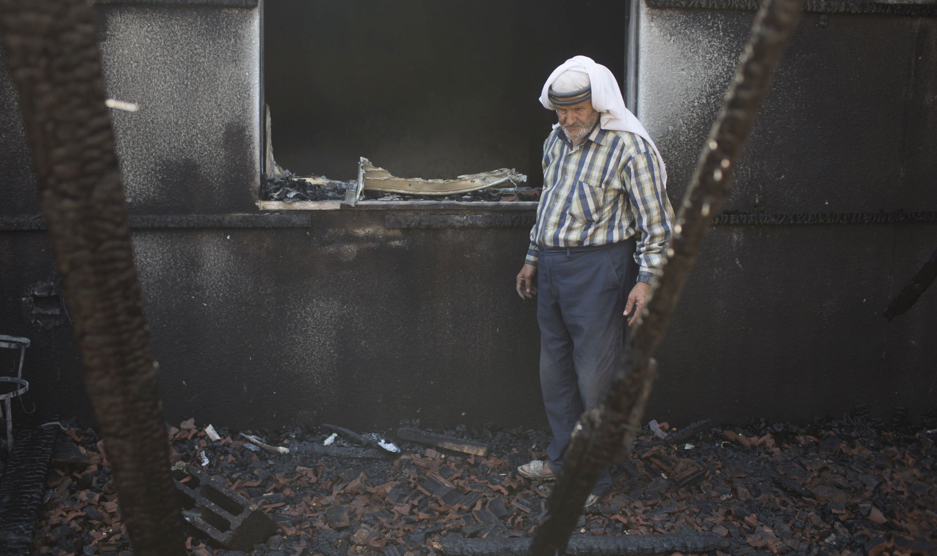 DUMA,WEST BANK - JULY 31:   Family members and relatives of 18 month old baby, Ali Saad-Dawabsheh, view the remains of their house after a fire which was suspected to have been set by Jewish extremists on July 31, 2015 in the Palestinian village of Duma, West Bank.  A house fire in the Palestinian village of Duma, West Bank, suspected to have been set by Jewish extremists, killed an 18-month-old Palestinian child, injured both parents and a four year old brother. (Photo by Oren Ziv/Getty Images)