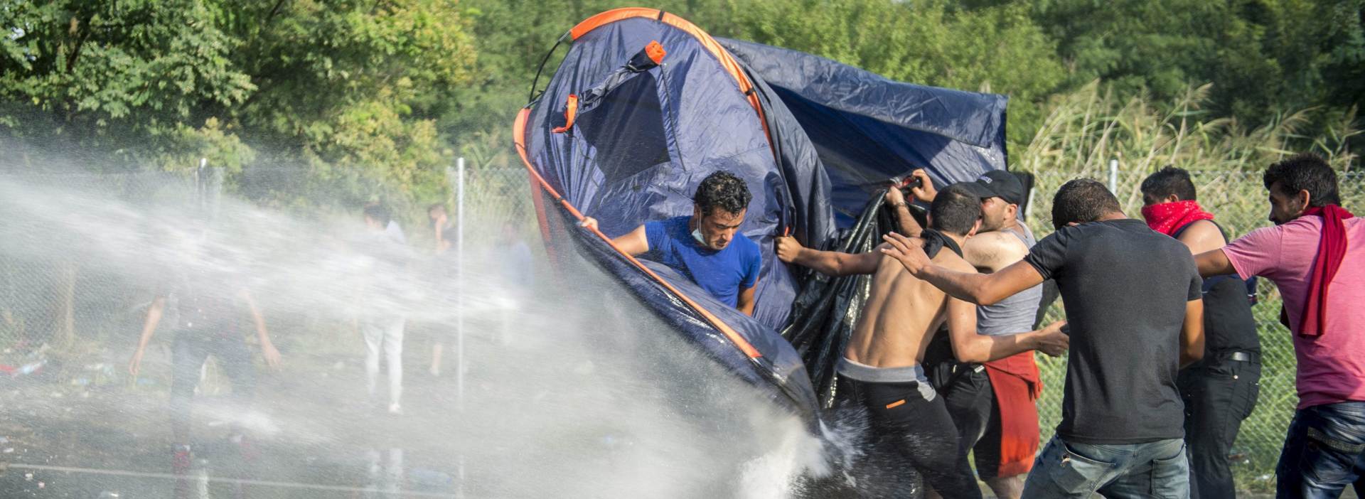 epa04933528 Hungarian police use water canons against demonstratring migrants at the border crossing into Hungary, near Horgos, Serbia, 16 September 2015. The border crossing was closed by the Hungarian police after the Hungarian government declared a state of crisis due to mass migration, meaning special measures to fight illegal immigration, in two Hungarian countries bordering Serbia.  EPA/TAMAS SOKI HUNGARY OUT