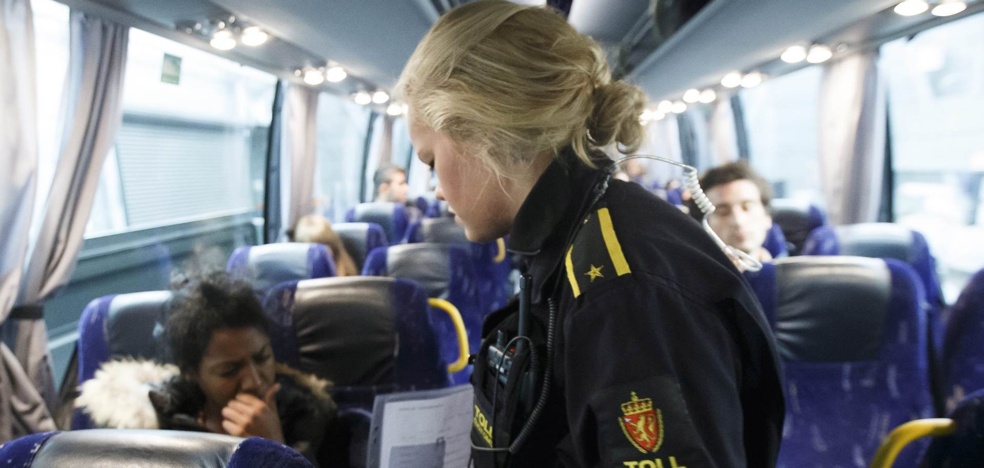 epa04934819 A picture made abvailable on 17 September 2015 of a Norwegian Customs official checking the identity of a woman from Eritrea on the night bus from Malmo, in Svinesund, Norway, 10 September 2015. Norway and Finland on 04 september had raised projections of the number of asylum-seekers expected this year, citing a spike in applications last month. Almost a third of the applicants in August were Syrians.  EPA/HEIKO JUNGE
