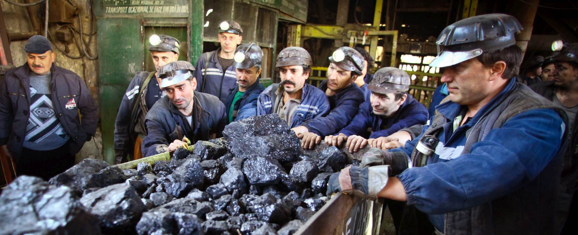 epa05003308 Coal miners push the last mine truck filled with coal extracted from Romania's deepest and oldest coal mine stands on the tracks of the mine in Petrila, some 400 kilometers west of Bucharest, Romania, 30 October 2015. The mine which reaches a depth of some 1,000 meters and was founded 156 years ago, was closed on 30 October according to some international agreements, considering it an uncompetitive mine. Media reports say that an initiative launched a petition to preserve the mine dubbed the 'Academy of Romanian Mining' because of its complexity as a heritage site for the legacy of the Romanian industrial era.  EPA/MIHAI BARBU