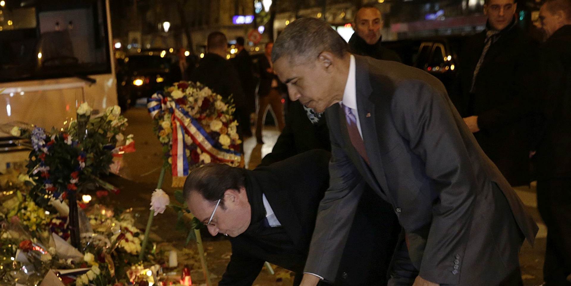 epa05048186 US President Barack Obama (R) and French President Francois Hollande (C) pay tribute to the victims of the 13 November attacks in front of the Bataclan concert venue, on the eve of  the opening of the COP21 Conference, Paris, France, 29 November 2015. The 21st Conference of the Parties (COP21) due to be held in Paris from 30 November to 11 December will proceed as planned, despite the terrorist attacks of 13 November.  EPA/PHILIPPE WOJAZER / POOL MAXPPP OUT