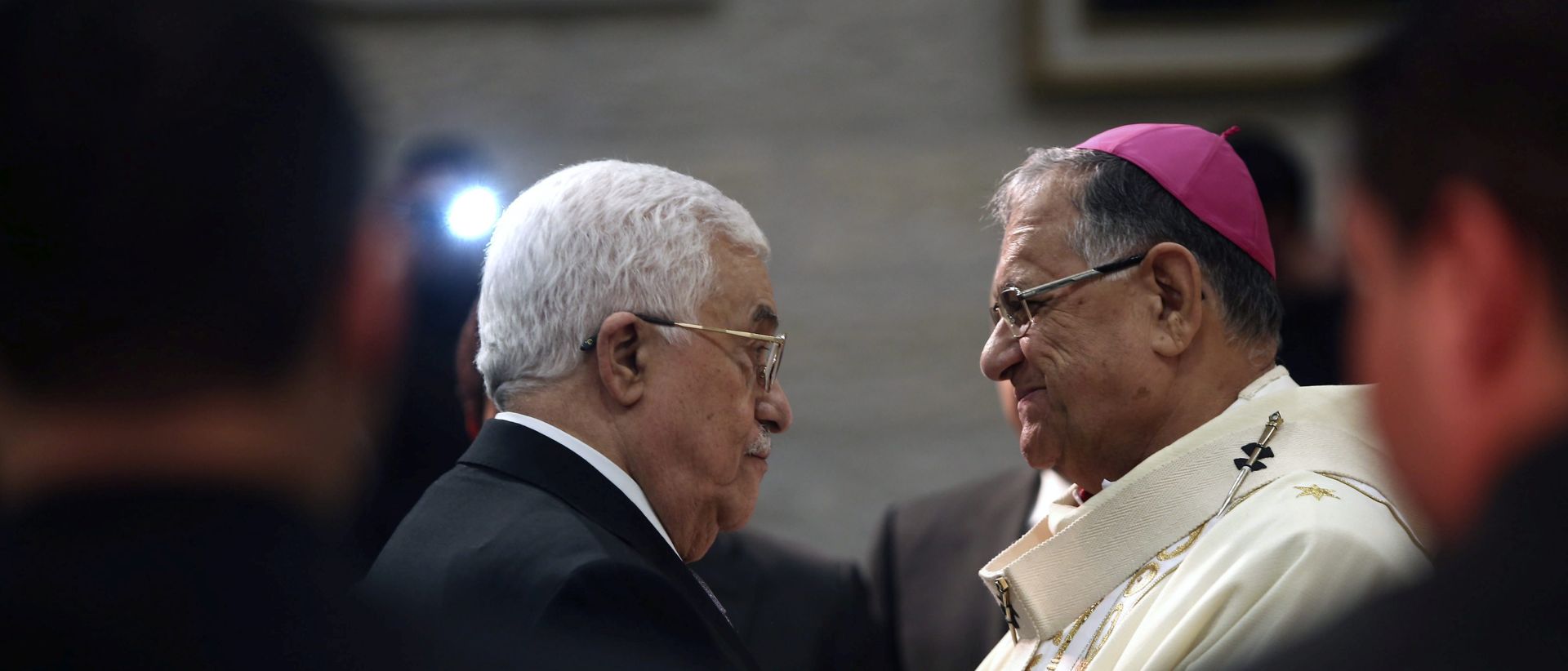 epa05080396 Palestinian President Mahmoud Abbas (L) greets the Latin Patriarch of Jerusalem Fouad Twal during a Christmas Midnight Mass at the Church of the Nativity in the town of Bethlehem, the West Bank, 25 December 2015.  EPA/FADI AROURI/POOL