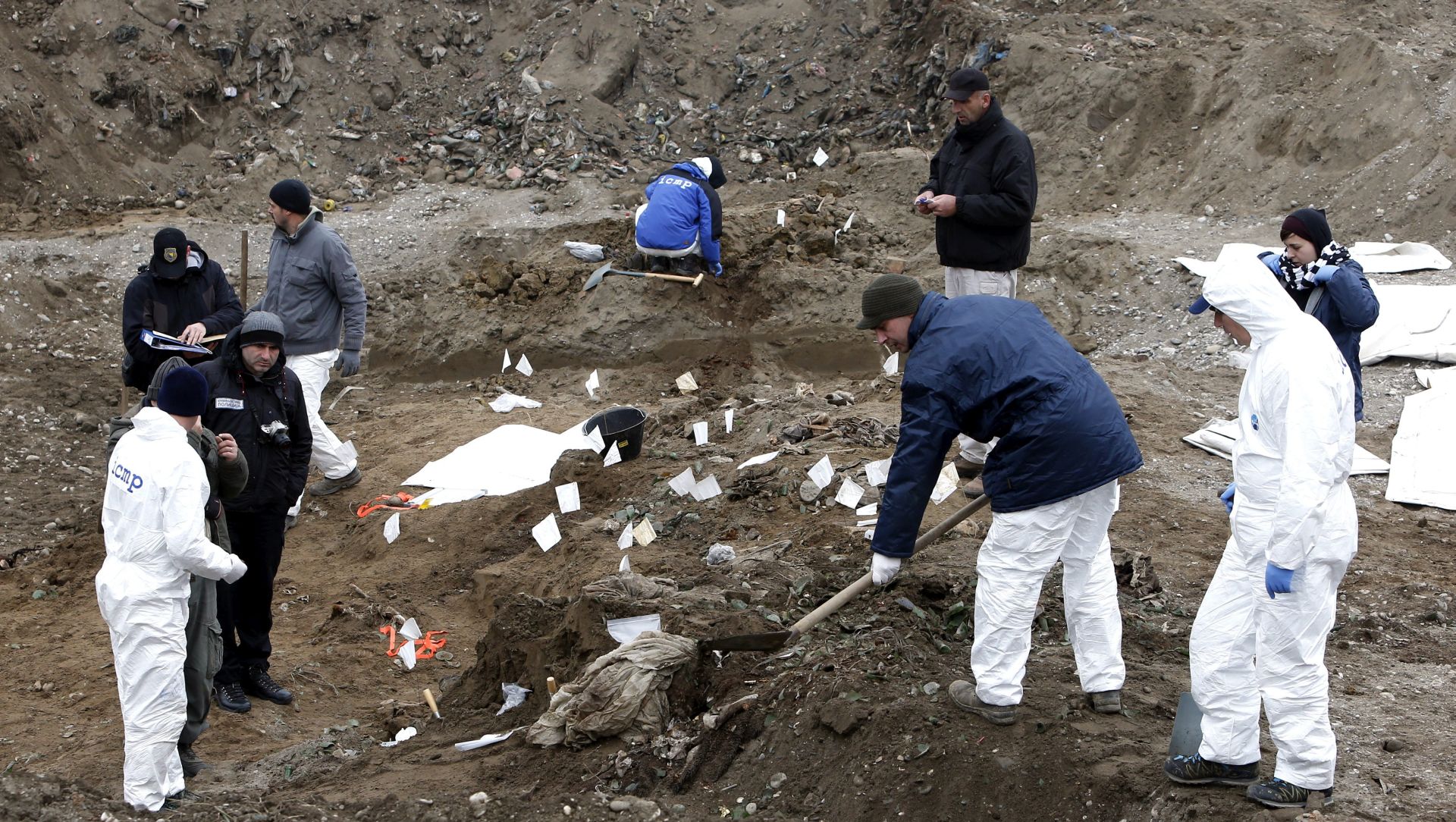 epa05069814 Forensic experts examine a mass grave in Kozluk, northeast Bosnia, 170 km from Sarajevo,  Bosnia and Herzegovina, 15 December 2015, near the site of the notorious Srebrenica massacre in 1995. The remains of several people have already been found in the grave which is believed to contain even more bodies. More than 8,000 Bosnian Muslims were killed by Serbian forces after the fall of Srebrenica 1995, which is regarded a war crime and the worst massacre in Europe since World War II.  EPA/FEHIM DEMIR