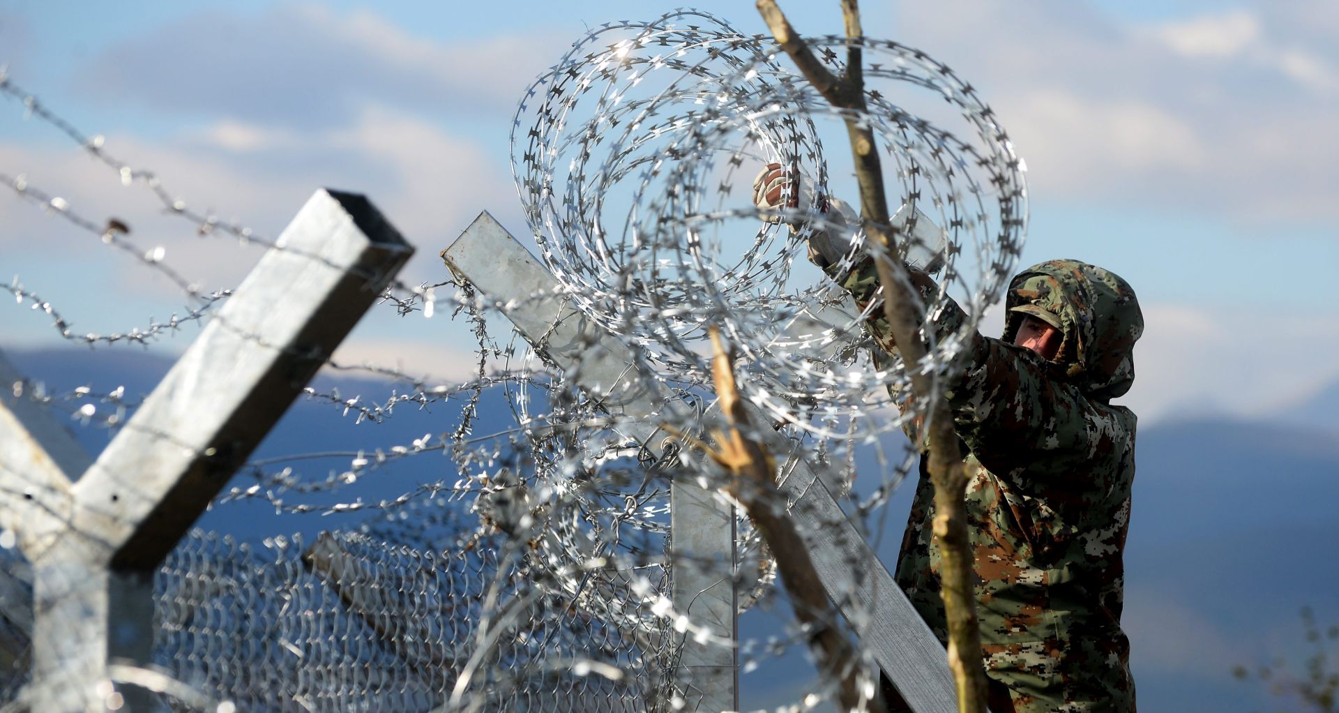 epa05046874 A Macedonian army soldier finish a razor-wired fence at the border with Greece, near Gevgelija, The Former Yugoslav Republic of Macedonia, 29 November 2015.  The Macedonian Army had on 16 November begun clearing terrain as it prepared the ground for a possible fence along the Greek border that would slow the flow of refugees crossing its terrain. The Macedonian army's engineering units started putting up the fence expected to be finished within 24 hours and to be over four kilometers long. Macedonian official state that the border will stay open and all the refugees that are from the regions overrun with military conflicts will be let through. Macedonia, Serbia and Croatia had started restricting access to migrants on the Balkan route to Syrians, Iraqis and Afghans. It is a part of a joint effort to reduce the number of asylum seekers streaming into the European Union.  EPA/NAKE BATEV