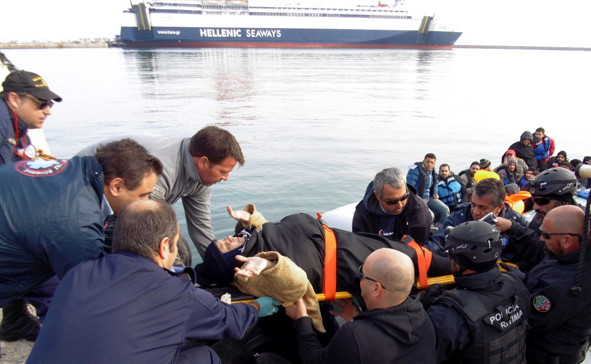 epa05070199 Coast guards and volunteers carry a woman form an overloaded rubber dinghy with refugees and migrants, following a successful rescue operation on the Greek island of Lesbos (Lesvos), Greece, 15 December 2015, after crossing the Aegean Sea from Turkey. Around 800,000 migrants and refugees are estimated to have arrived in Greece since the beginning of the year, with most moving on - sometimes unhindered - to wealthy northern European countries.  EPA/STRINGER