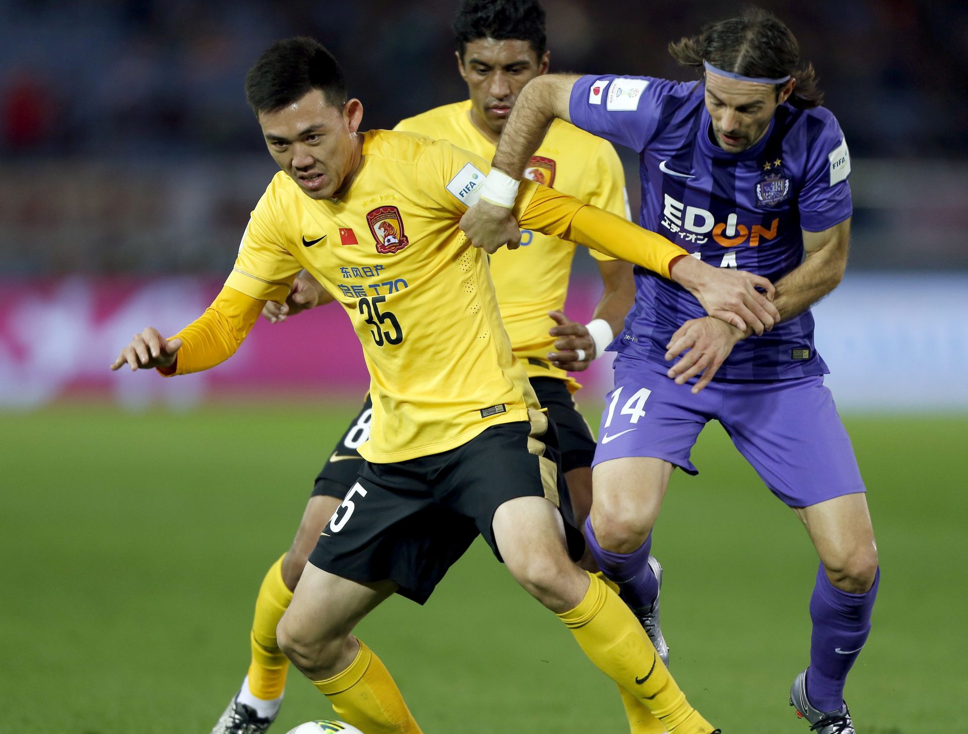epa05076089 Guangzhou Evergrande FC defender Xuepeng Li (L) in action against Sanfrecce Hiroshima's midfielder Mihael Mikic (R) during the third place match of the FIFA Club World Cup 2015 in Yokohama, south of Tokyo, Japan, 20 December 2015.  EPA/CHRISTOPHER JUE