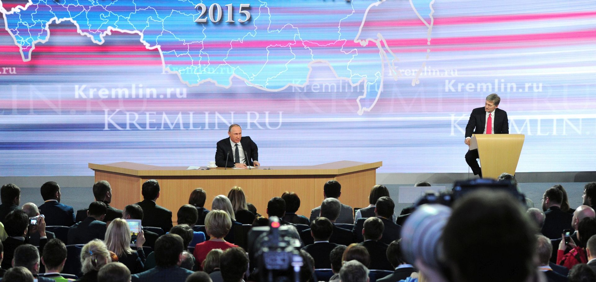 epa05072056 Russian President Vladimir Putin (Back L) and his press Secretary Dmitry Peskov (Back R) attend the annual news conference of Russian President at the World Trade Center in Moscow, Russia, 17 December 2015. He was expected to address questions on domestic and international issues, especially Russia's involvement in Syria and Ukraine, and its fight against international terrorism.  EPA/MIKHAIL KLIMENTYEV / SPUTNIK / KREMLIN POOL MANDATORY CREDIT