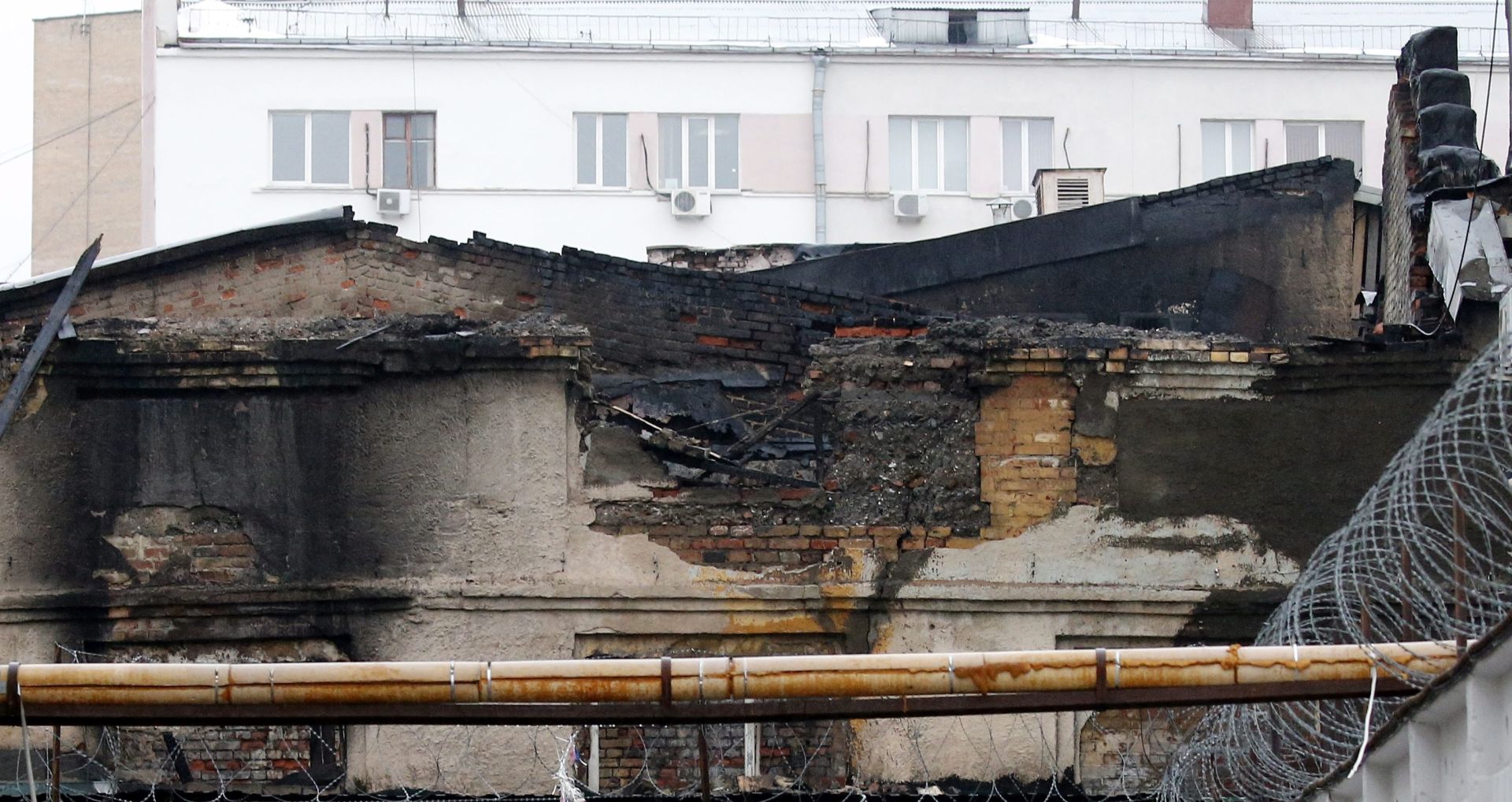 epa05137079 A collapsed scorched roof at the site of a fire at a sewing workshop in Stromynka Street in Moscow, Russia, 31 January 2016. At least 12 people were killed, including three children, after a fire swept through a sewing factory in north-eastern Moscow, authorities said. The blaze erupted late Saturday, damaging about 3,000 square meters of the building and causing a portion of the roof to collapse, Russian news agencies reported. A preliminary probe indicates the fire was caused by arson and a murder investigation has been launched, the TASS news agency reported, citing anonymous law enforcement officials.  EPA/MAXIM SHIPENKOV