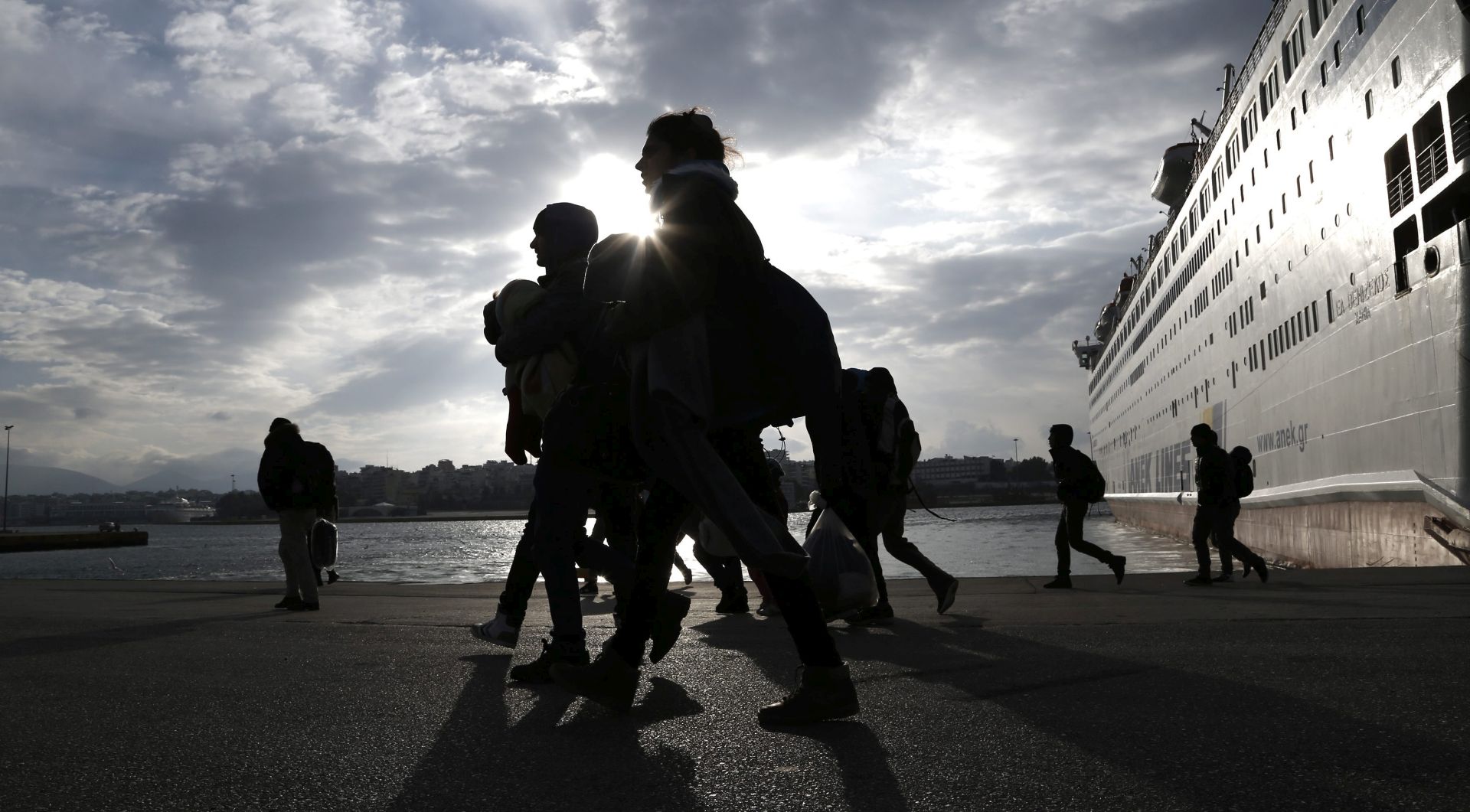epa05120126 Refugees and migrants walk after disembarking from the ferry 'Eletherios Venizelos' at the port of Piraeus, near Athens, Greece, 23 January 2016. The ship 'Eleftherios Venizelos' arrived at the port of Piraeus carrying about 2,500 refugees and migrants that had landed on the Greek island of Myilene, coming from Turkey. Thousands of migrants continue to arrive on the Greek islands, after having crossed the Aegean sea, on their way to the European Union countries.  EPA/YANNIS KOLESIDIS