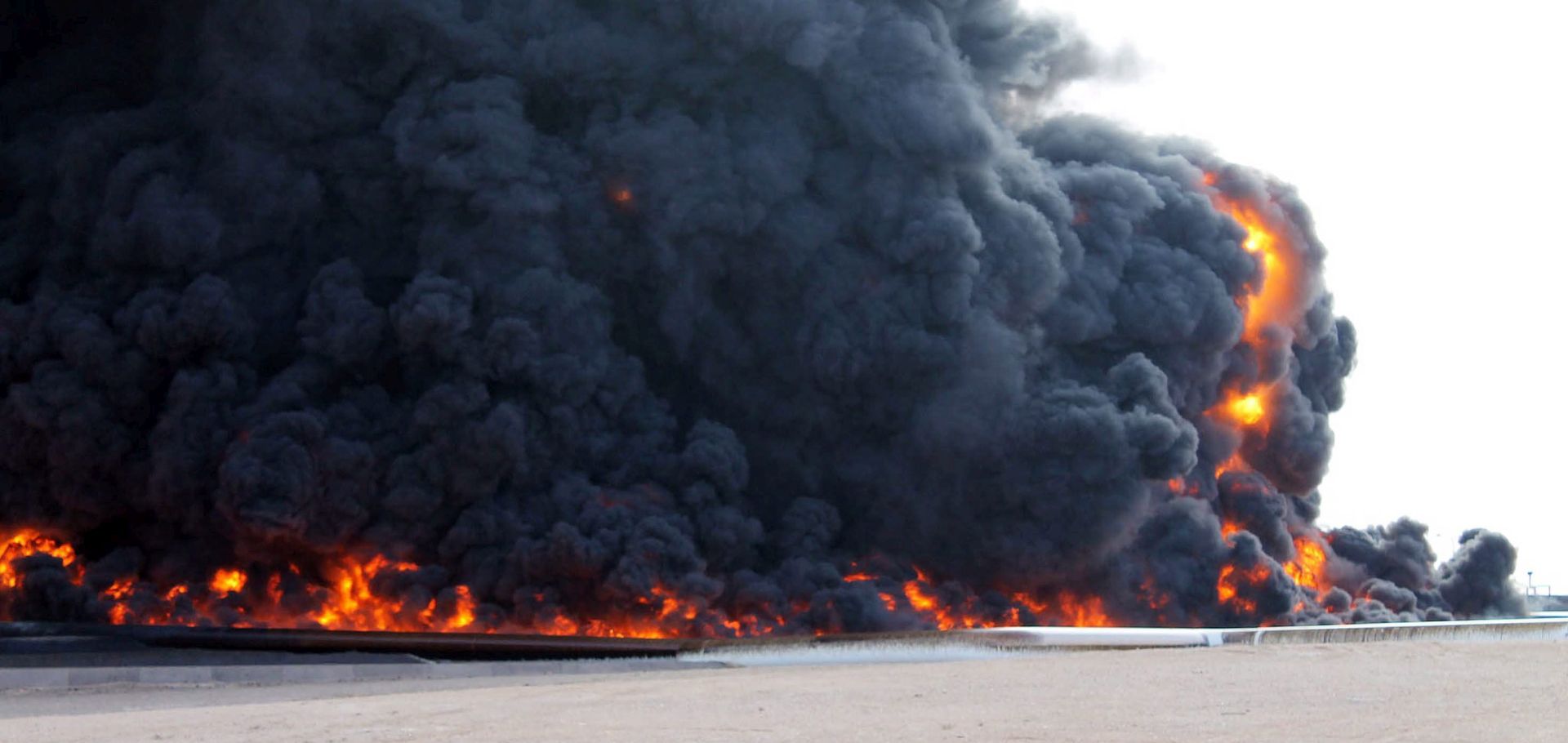 epa05087546 (FILE) A file picture dated 26 December 2014 showing smoke rising from a large fuel depot fire, al-Sidra, Libya, during  fighting. Islamic State militants on 04 January 2016 launched an attack on the port of al-Sidra, Libya's largest oil terminal, military officials said. Clashes between guards at the terminal and the jihadists led to the death of two guards and 10 of the attackers, Omar al-Hassi, spokesman for Libya's Petroleum Guards Force, said. A military official loyal to Libya's internationally recognized government, based in Tobruk in the far east of the country, said the air force had intervened and rebuffed the attack.
Islamic State, which is based mainly in Syria and Iraq, controls an area of Libya's Mediterranean coast centred around the towns of Sirte and al-Nofaliyeh, west of al-Sidra.  EPA/STRINGER