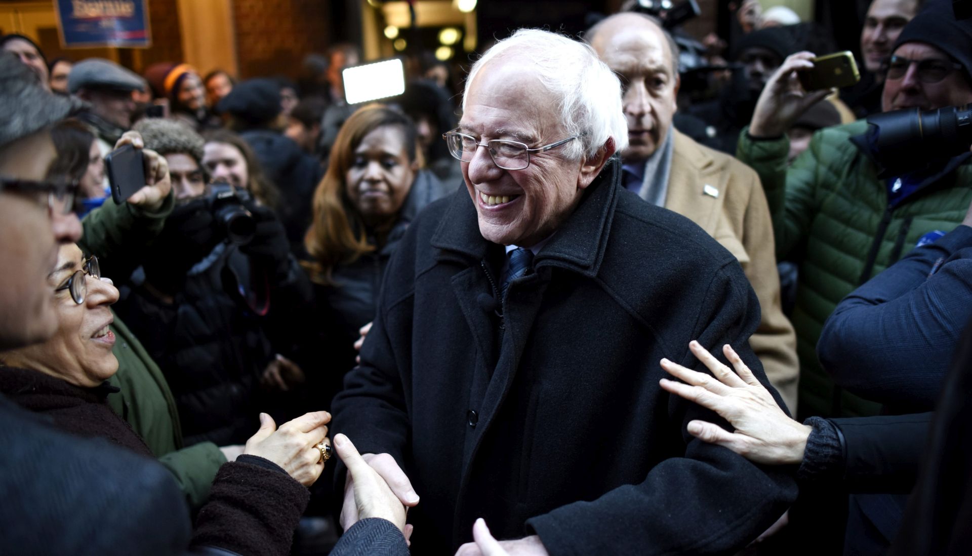 epa05089039 United States Democratic presidential candidate Senator Bernie Sanders (C), of Vermont, shakes hands with supporters following a speech about Wall Street and his plans for new financial regulations at Town Hall in New York, New York, USA, 05 January 2016.  EPA/JUSTIN LANE
