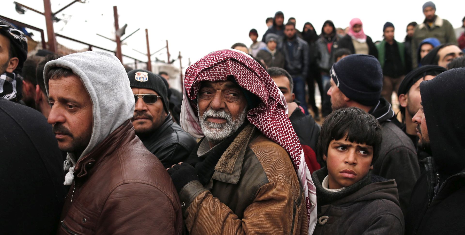 epa05145817 Syrian refugees wait for food near a refugee camp in Bab Al-Salama city, northern Syria, 06 February 2016. A new wave of Syrian refugees leaving the country is expected to reach Turkey, according to local news. The Syrian Observatory for Human Rights said some 40,000 people were on the move in Aleppo province, after the Syrian army entered two pro-government Shiite towns outside of Aleppo and advanced against rebel forces in the northern province a day earlier, threatening to entirely encircle the opposition-held parts of the key city.  EPA/SEDAT SUNA