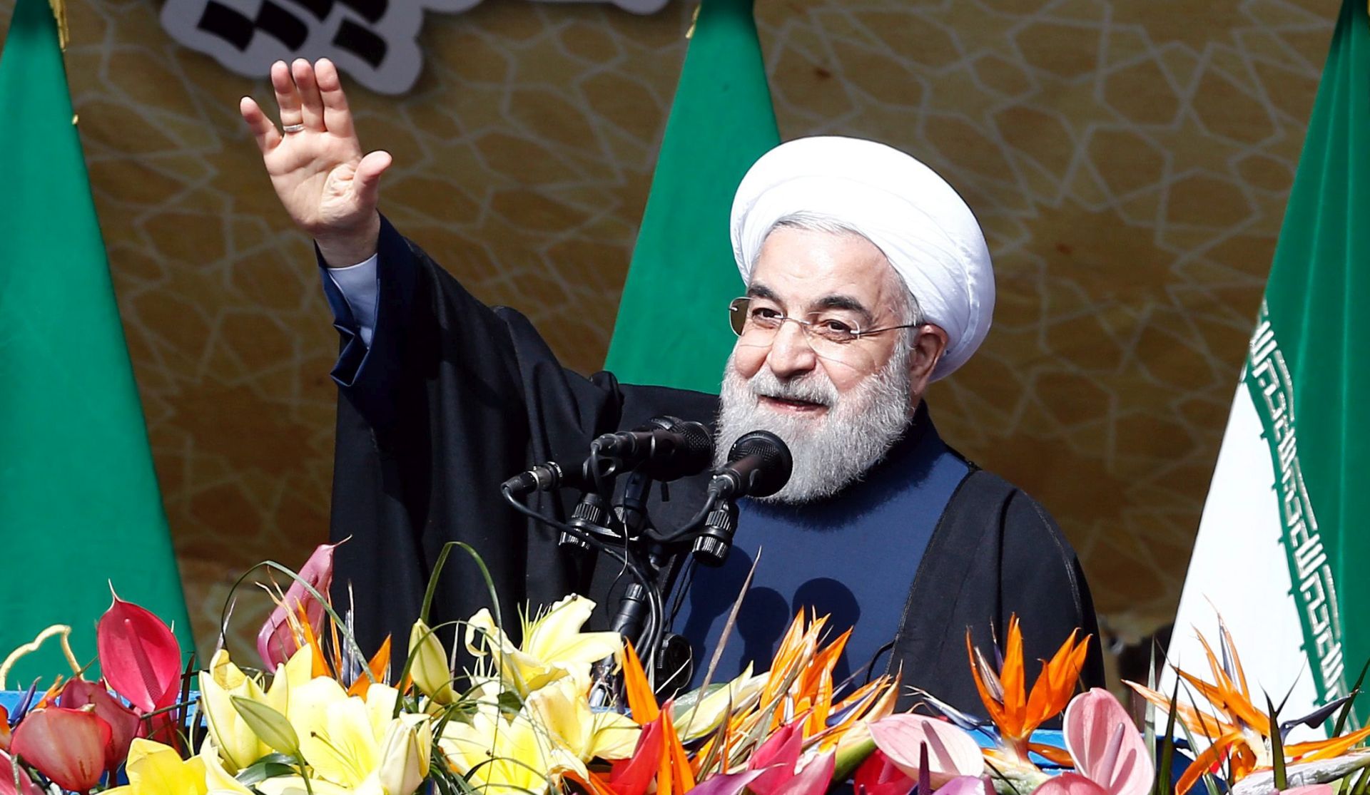 epa05154096 Iranian President Hassan Rouhani waves to the crowd during a ceremony marking the 37th anniversary of the 1979 Islamic revolution, at the Azadi (Freedom) square in Tehran, Iran, 11 February 2016. The event mark the 37th anniversary of the Islamic revolution, which came ten days after Ayatollah Ruhollah Khomeini's return from his exile in Paris to Iran, toppling the monarchy system and forming the Islamic republic.  EPA/ABEDIN TAHERKENAREH
