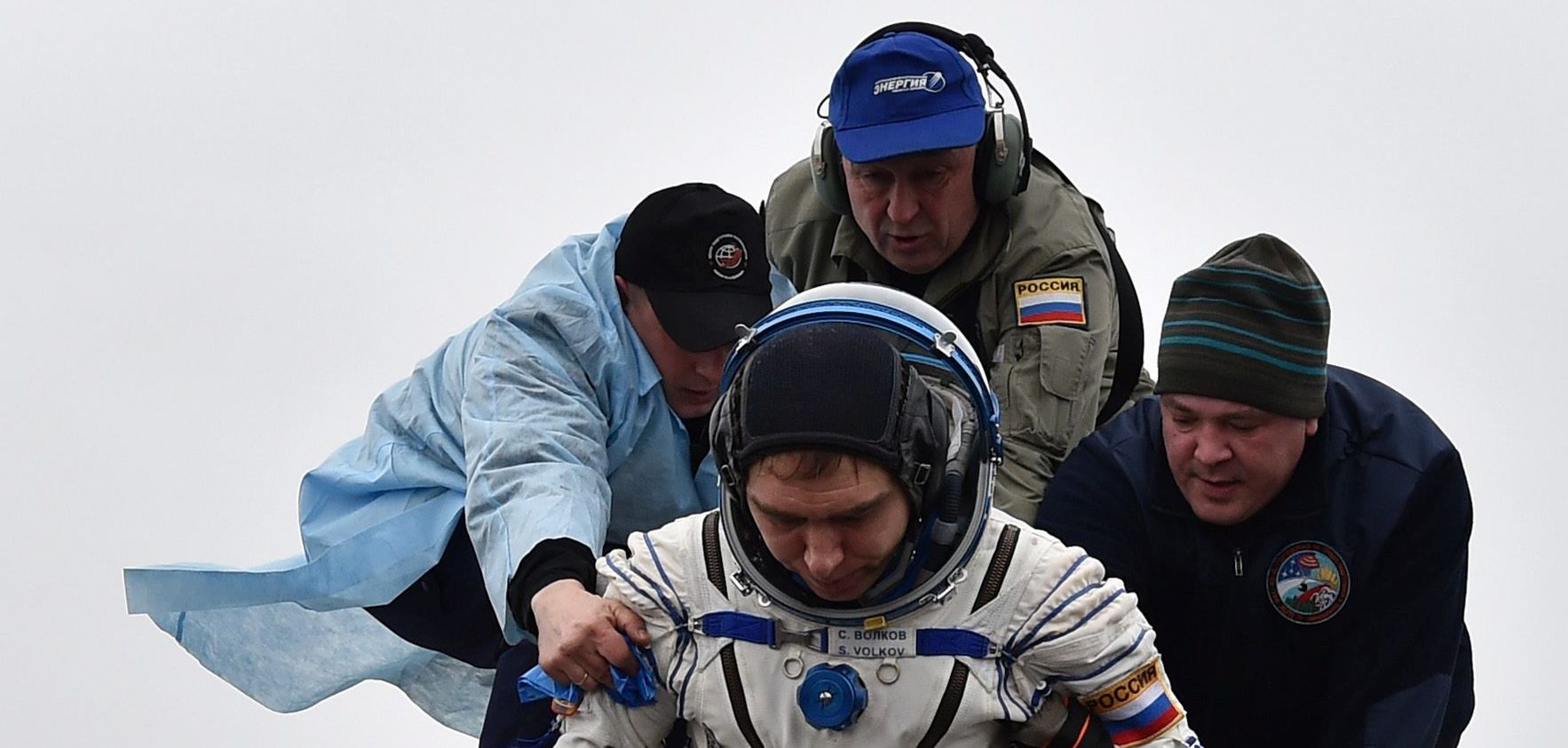 epa05189897 Ground personnel help International Space Station (ISS) crew member Sergei Volkov of Russia to get off the Soyuz TMA-18M space capsule after landing near the town of Dzhezkazgan (Zhezkazgan), Kazakhstan, 02 March 2016. US astronaut Scott Kelly and Russian cosmonaut Mikhail Kornienko returned to Earth on March 2 after spending almost a year in space in a ground-breaking experiment foreshadowing a potential manned mission to Mars.  EPA/KIRILL KUDRYAVTSEV/POOL