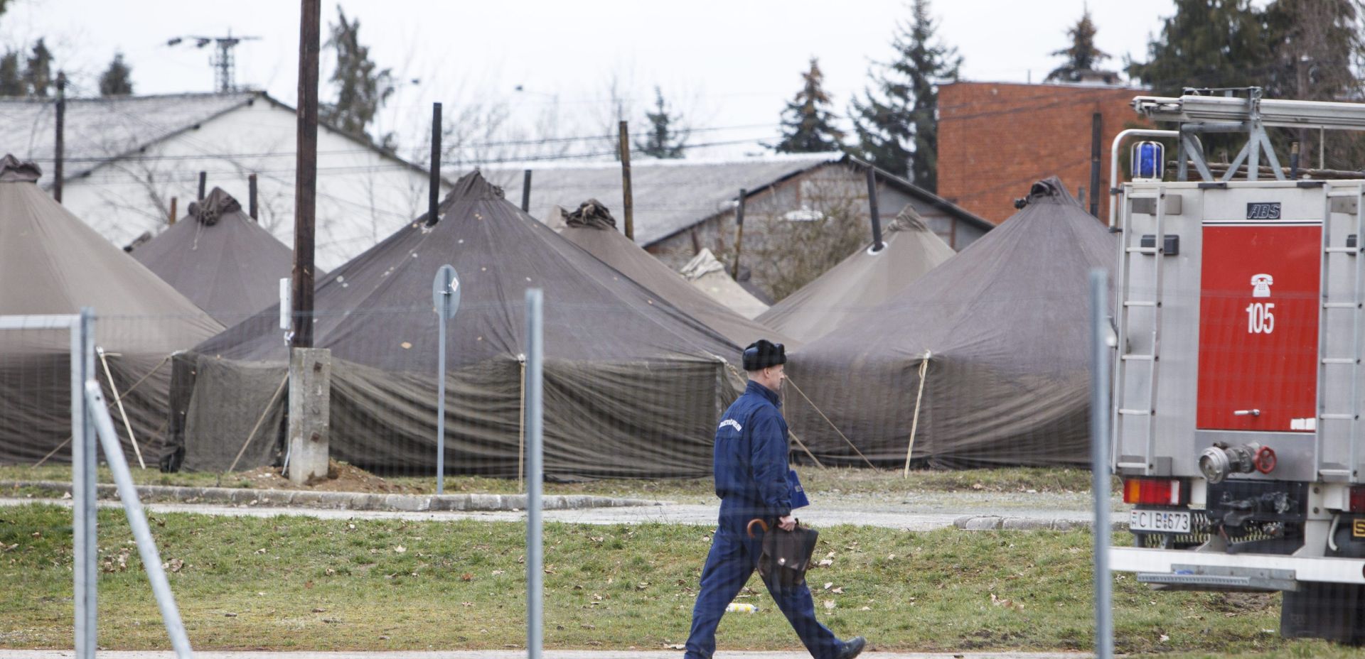 epa05188974 A policeman walks past tents of a reception centre for migrants and refugees in Kormend, 233 kms southwest of Budapest, Hungary, 01 March 2016. This day the Hungarian authorities have commenced the construction of the temporary camp, which will serve to accommodate about three hundred people.  EPA/GYORGY VARGA HUNGARY OUT