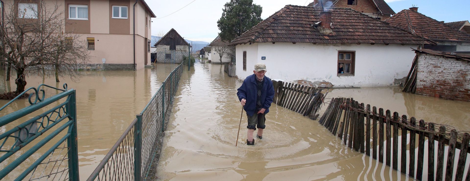 epa05199481 An old man wades through a flooded village near Pozega, some 155 kilometers south-west of the capital Belgrade, Serbia, 07 March 2016. Rain-swollen rivers have flooded dozens of houses, roads and farming land and caused local authorities in several municipalities to declare the state of emergency.  EPA/KOCA SULEJMANOVIC