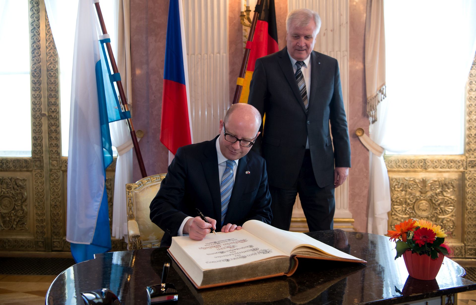 epa05204422 Bohuslav Sobotka (L), Prime Minister of the Czech Republic, signs the guestbook of the Bavarian state government, with Horst Seehofer, Premier of the German state of Bavaria, looking on, in Munich, Germany, 10 March 2016. Sobotka is on a two-day visit to Bavaria.   EPA/SVEN HOPPE