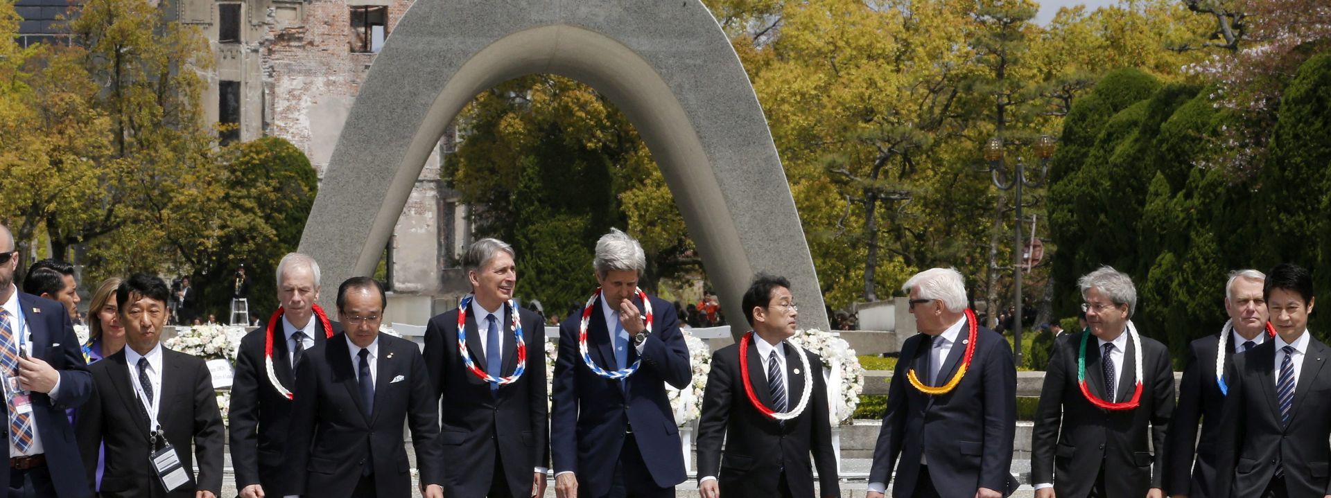 epa05253834 US Secretary of State John Kerry (C), Mayor of Hiroshima Kazumi Matsui (4-L), Japanese Foreign Minister Fumio Kishida (5-R), German Foreign Minister Frank-Walter Steinmeier (4-R) and British Foreign and Commonwealth Minister Philip Hammond (5-L) wearing necklaces made of paper cranes in honor of Sadako Sazaki, the girl who became the symbol of atomic horror after dying of leukemia, after a wreath laying ceremony for the victims of the atomic bombing in 1945, at Hiroshima Peace Memorial Park, in Hiroshima, Hiroshima Prefecture, western Japan, 11 April 2016. The Group of Seven (G7) countries' foreign ministers gathered to talk about various themes including nuclear disarmament and non-proliferation in the atomic bombing city of Hiroshima. In picture Italian Foreign Minister Paolo Gentiloni (3-R) and French Foreign Minister Jean-Marc Ayrault (2-R).  EPA/KIMIMASA MAYAMA