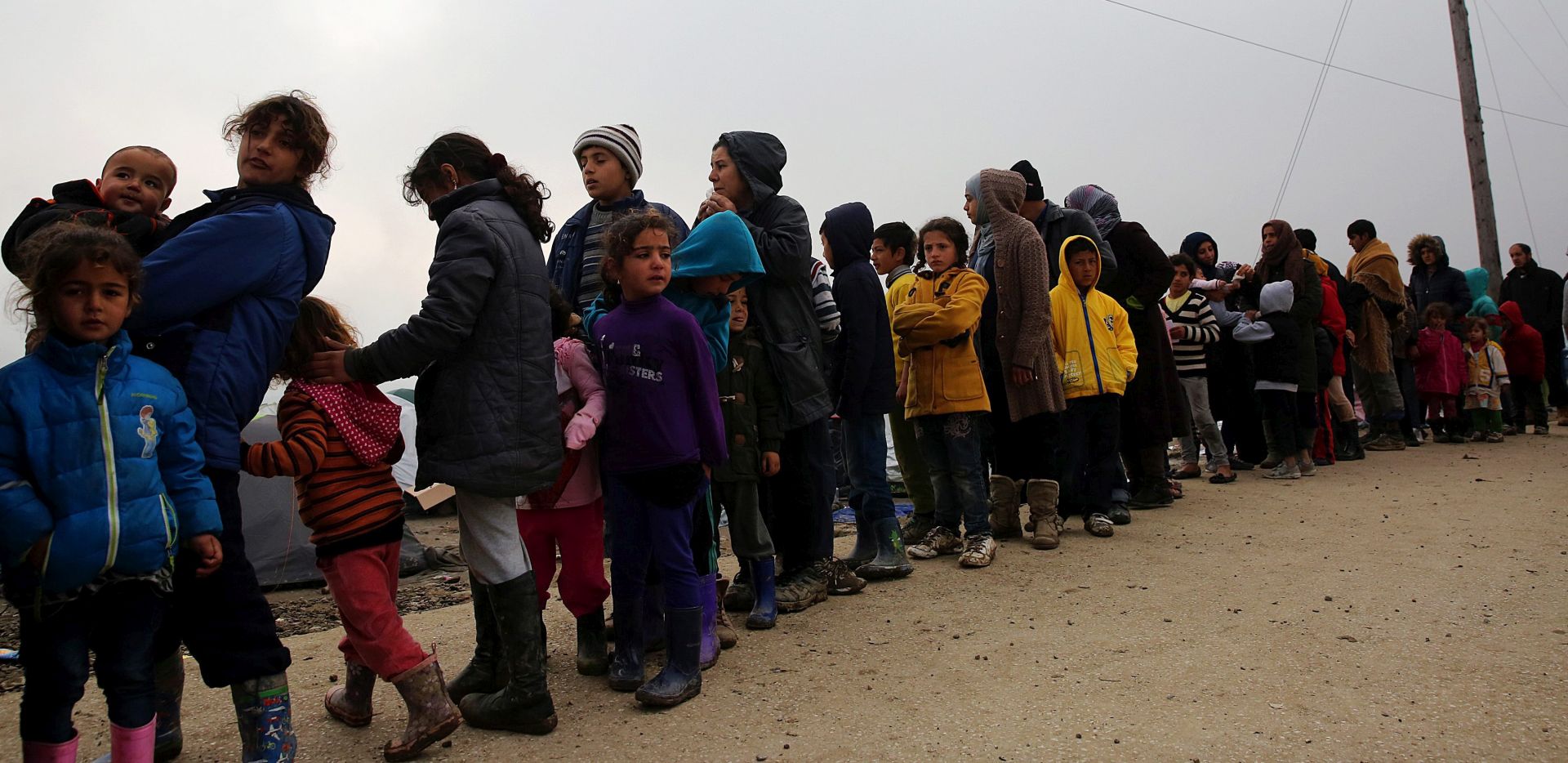 epa05217884 Refugees wait in line to receive food in the make-shift camp for refugees in Idomeni, north Greece, some meters from the borderline with FYROM, 18 March 2016. Migration restrictions along the so-called Balkan route, the main path for migrants and refugees from the Middle East to the EU, has left thousands of migrants trapped in Greece.  EPA/ORESTIS PANAGIOTOU