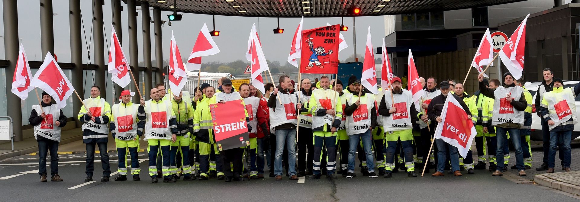 epa05279175 Airport employees carry banners and flags during a rally at the airport of Hanover, in Hanover, Germany, 27 April 2016. German trade union Verdi has called for strikes to increase pressure on employers in the ongoing collective wage negotiations. Verdi is demanding a six-percent pay hike, an additional 100 euro in wages for apprentices and permanent positions upon the completion of apprenticeships.  EPA/HOLGER HOLLEMANN