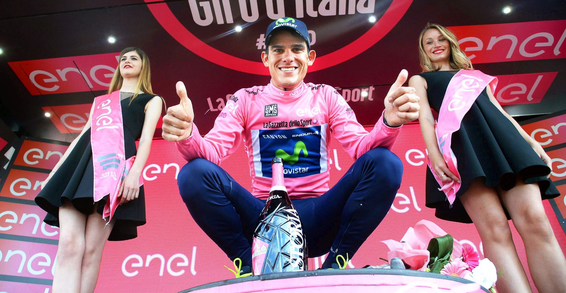 epa05319670 Costa Rican rider Andrey Amador (C) of the Movistar Team celebrates on the podium wearing the overall leader's pink jersey after the 13th stage of the Giro d'Italia cycling race over 170km from Palmanova to Cividale del Friuli, Italy, 20 May 2016.  EPA/LUCA ZENNARO