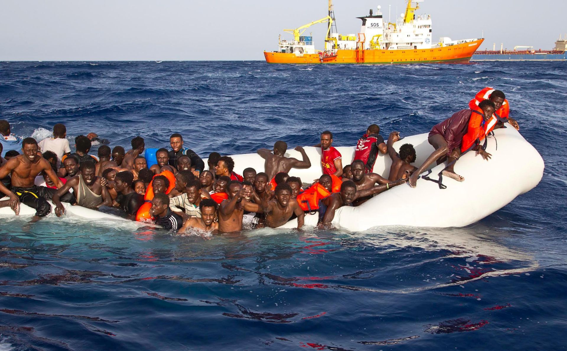 epa05265406 A handout photgraph made available by the Ong Sos Méditerranée showing migrants on a snking inflatable boat before being rescued by  the Aquarius ship of the humanitarian group SOS Mediterranee, and taken to  Lampesusa, Italy, 18 April 2016. Six bodies were recovered and 108 migrants were rescued from a semi-submerged rubber dinghy as boat arrivals accelerate amid calm seas. A private rescue ship, the Aquarius, run by humanitarian group SOS Mediterranee found the bodies on the rubber dingyon 17 April 2016.  EPA/ONG SOS MEDITERRANEE / HANDOUT  HANDOUT EDITORIAL USE ONLY/NO SALES