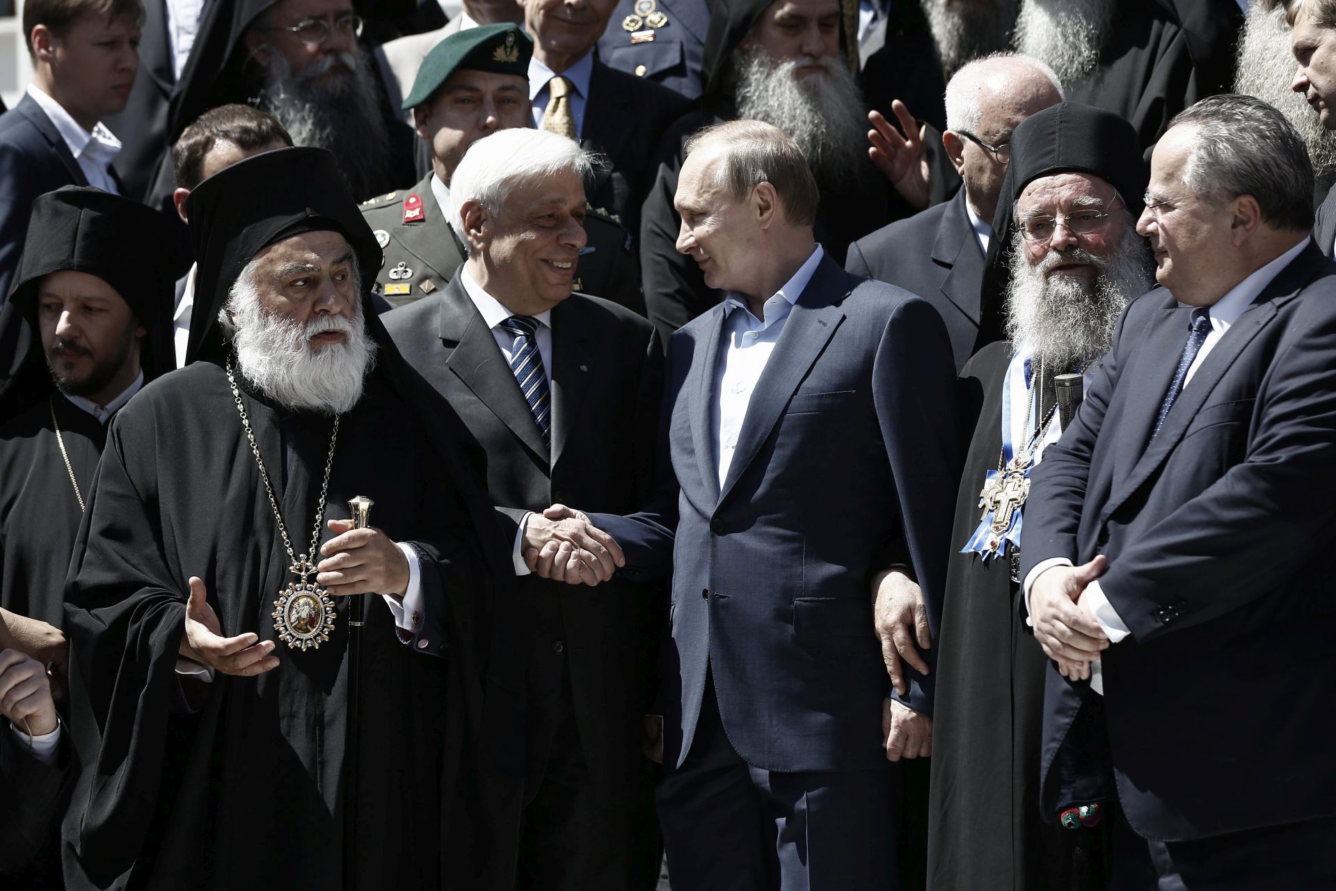epa05333661 Russian President Vladimir Putin (C) is shakes hands with Greek President Prokopis Pavlopoulos (C-L) next to Greek Foreign Minister Nikos Kotzias (R) during their visit in Mount Athos, in northern Greece, 28 May 2016. The Russian President is in Greece on a two-day official visit.  EPA/YANNIS KOLESIDIS