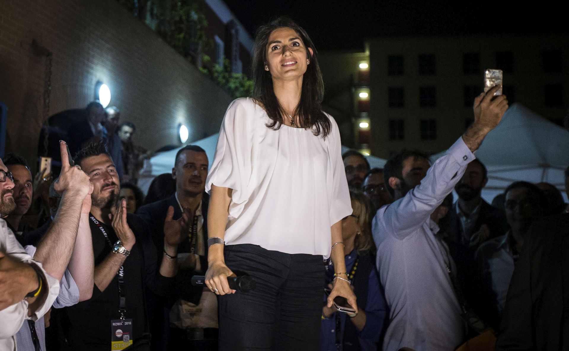 epa05378665 Virginia Raggi (C) of the anti-establishment Five Star Movement (Movimento Cinque Stelle, M5S) political party attends a meeting with supporters outside her caucus in Rome, Italy, 20 June 2016. Raggi, 37, will become Rome's first female mayor after winning in the mayoral elections run-off, according to exit polls.  EPA/ANGELO CARCONI