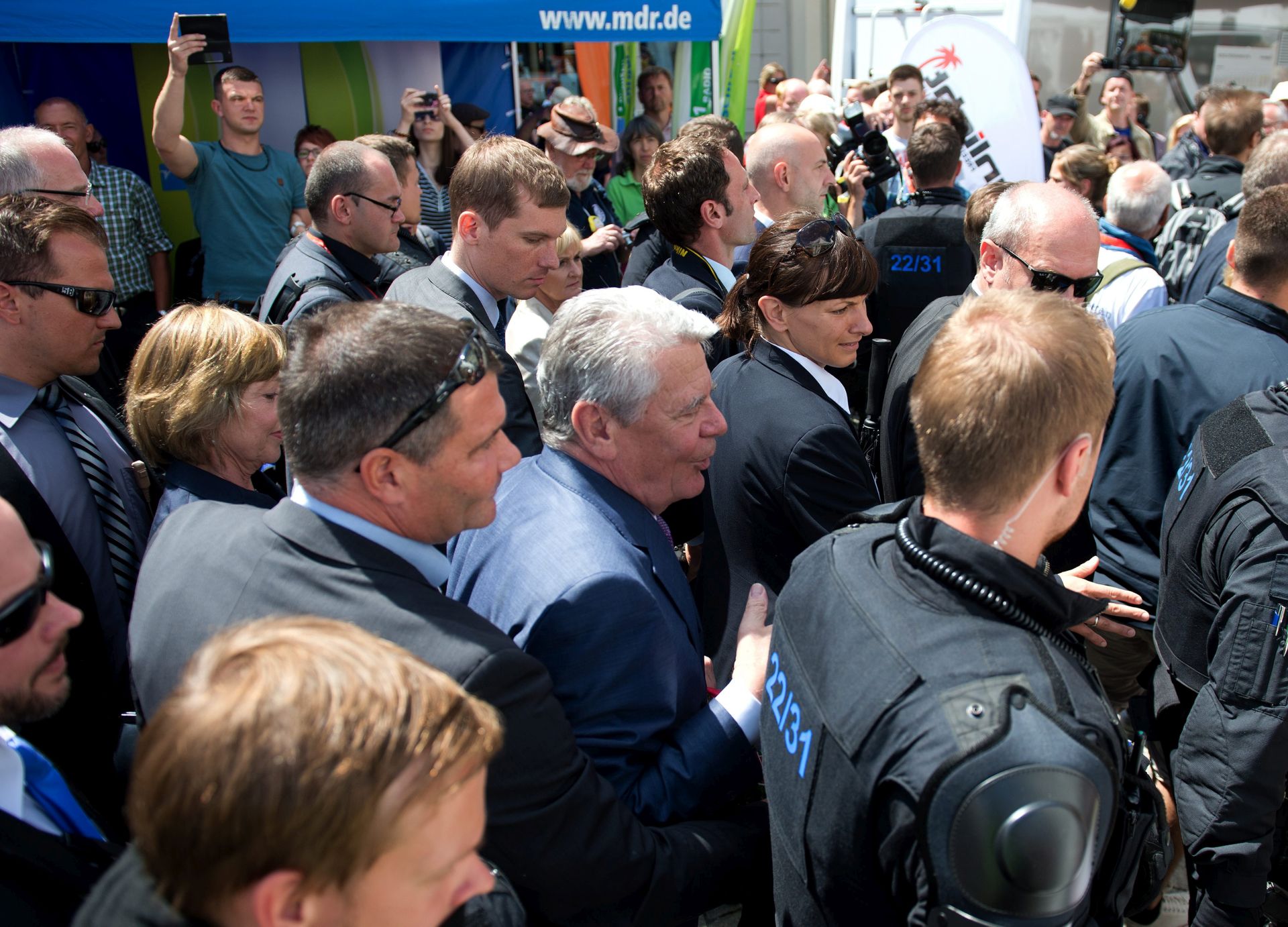epa05391810 German President Joachim Gauck (C) is surrounded by police during his visit to the 116th German Hiking Festival on the market square in Sebnitz, Germany, 26 June 2016. Gauck was insulted by upset protesters during his visit.  EPA/ARNO BURGI