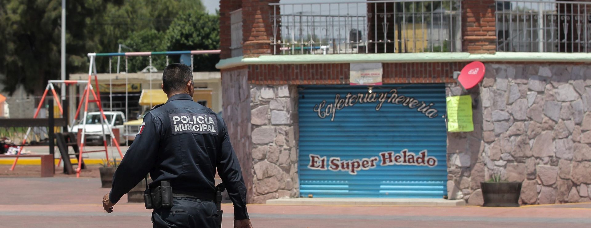 epa05329259 A police officer walks across the deserted central square of Santiago Atlatongo village, Mexico, 25 May 2016, where local residents killed two alleged kidnappers to death on 24 May. The Attorney's General Office explained that 18 people had been arrested for their possible participation in the lynching of three people accused of kidnapping a resident. Three alleged kidnappers were lynched, with two of them suffering fatal wounds after being attacked by hundreds of residents of the community, according to local media reports. Reports on 25 May state that the 18 people who were detained in connection with the lynching have been released.  EPA/ALEX CRUZ