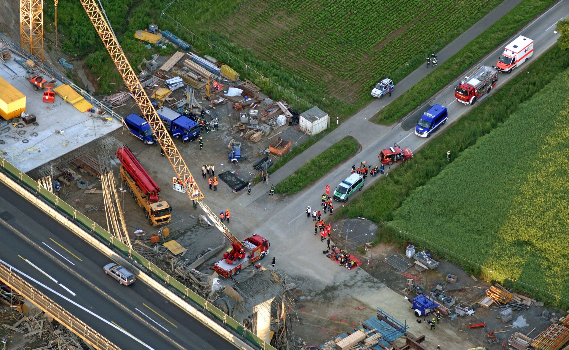 epa05368603 An aerial view of the site of the collapse of a part of the newly-built 'Talbruecke' replacement bridge, along the A7 motorway in Schraudenbach, near Werneck, Germany, 16 June 2016. One construction worker was killed and several others injured in the collapse at the construction site for a new highway bridge. Investigations into the cause of the accident are reportedly underway.  EPA/HAJO DIETZ