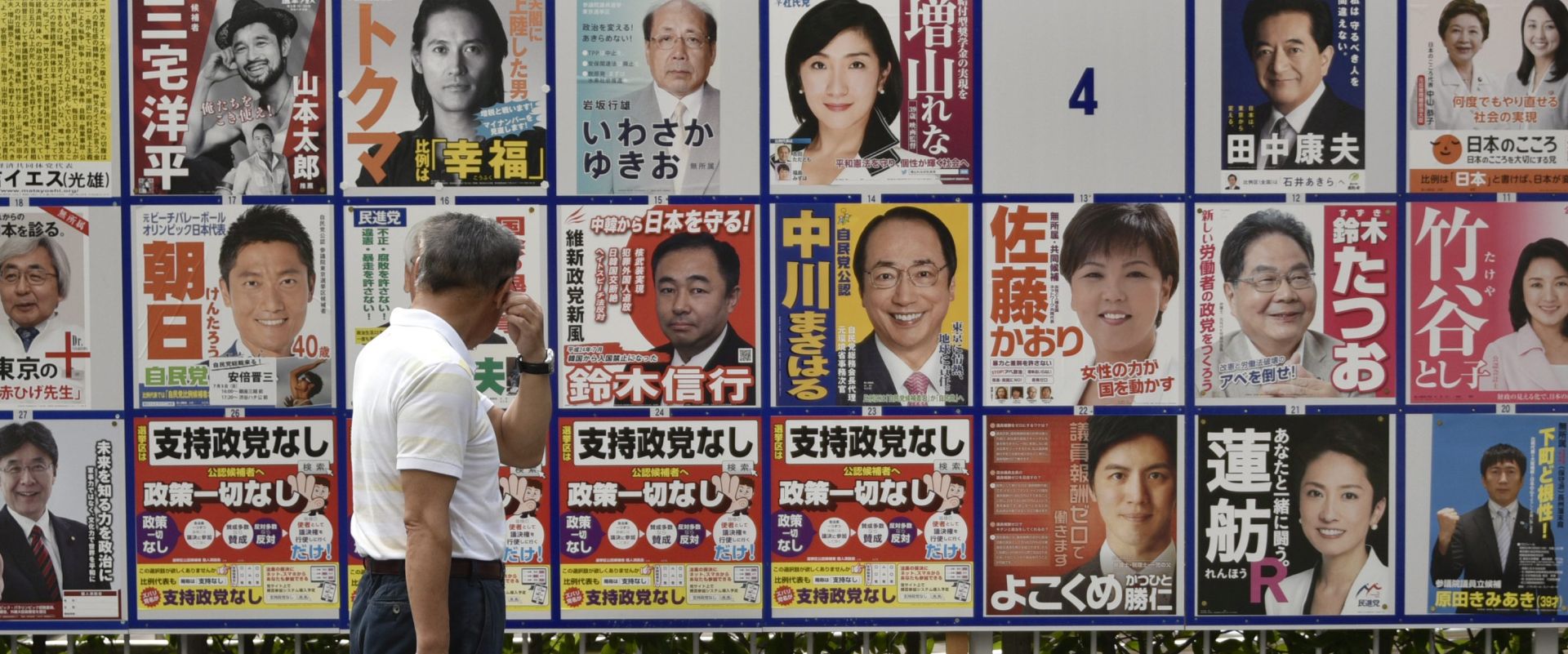 epa05412403 A man looks at posters of candidates for the coming upper house election in Tokyo, Japan, 07 July 2016. According to a survey by Kyodo News agency, the support rating for ruling Liberal Democratic Party (LDP) gained 2.6 points to reach 33.5 percent for the 10 July upper house election while main opposition Democratic Party remained at around 10 percent.  EPA/FRANCK ROBICHON