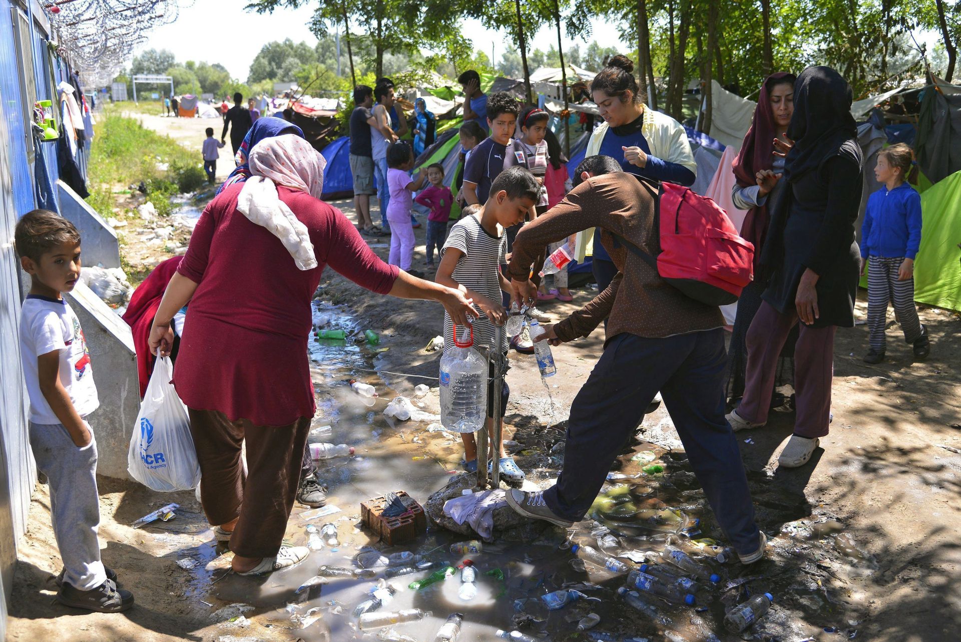 epa05421063 Migrants take water from a tap near the Hungarian border at Horgos, northern Serbia, 11 July 2016. After Hungary had completely sealed its borders in a move that was criticised by the United Nations High Commissioner for Refugees, UNHCR, many migrants are uncertain about how they could get to their desired destinations in the EU. According to media reports more than a million people had used the so-called Balkan-Route to western European countries before some countries took measures to close their borders for the stream of migrants.  EPA/EDVARD MOLNAR HUNGARY OUT