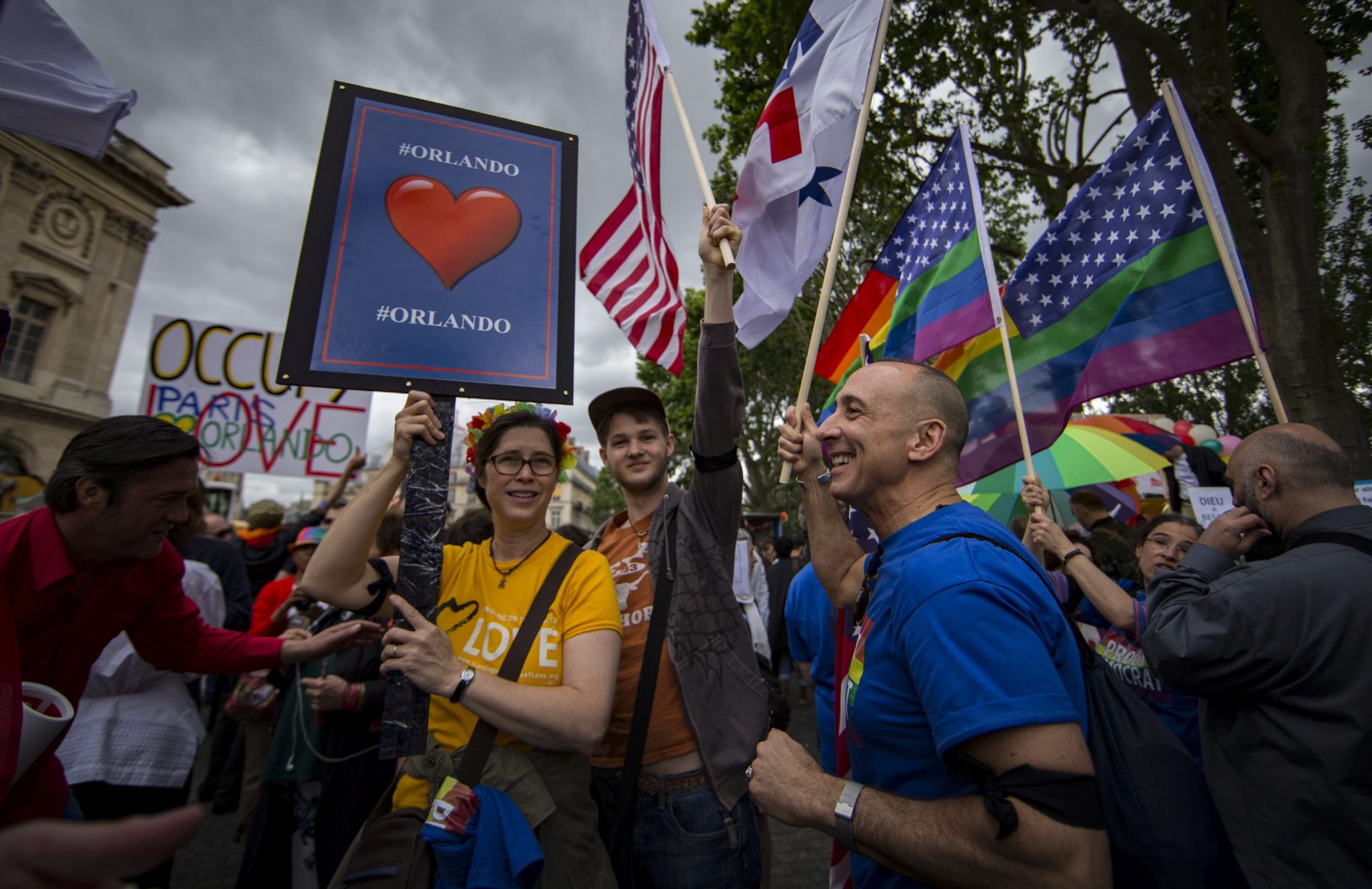 epa05403652 Members of the American community of Paris hold a placard in memory of the victims of the Orlando attacks, as they take part in the annual Gay Pride parade in Paris, France, 02 July 2016.  EPA/IAN LANGSDON