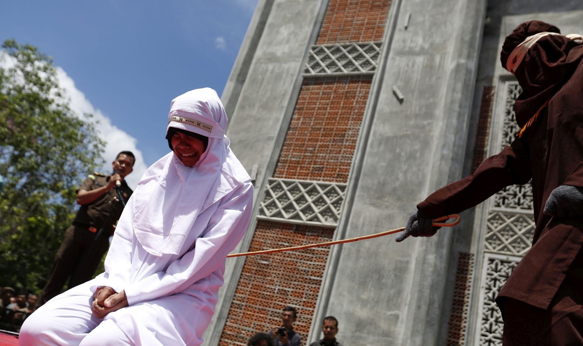 epa05450715 An Acehnese woman is whipped in front of the public at Al Furqon Mosque, Banda Aceh, Indonesia, 01 August 2016. Three Acehnese couples were sentenced to be whipped for violating the sharia law for dating between a man and a woman, a violation of sharia law. Whipping is one form of punishment imposed in Aceh for violating Islamic Sharia law.  EPA/HOTLI SIMANJUNTAK