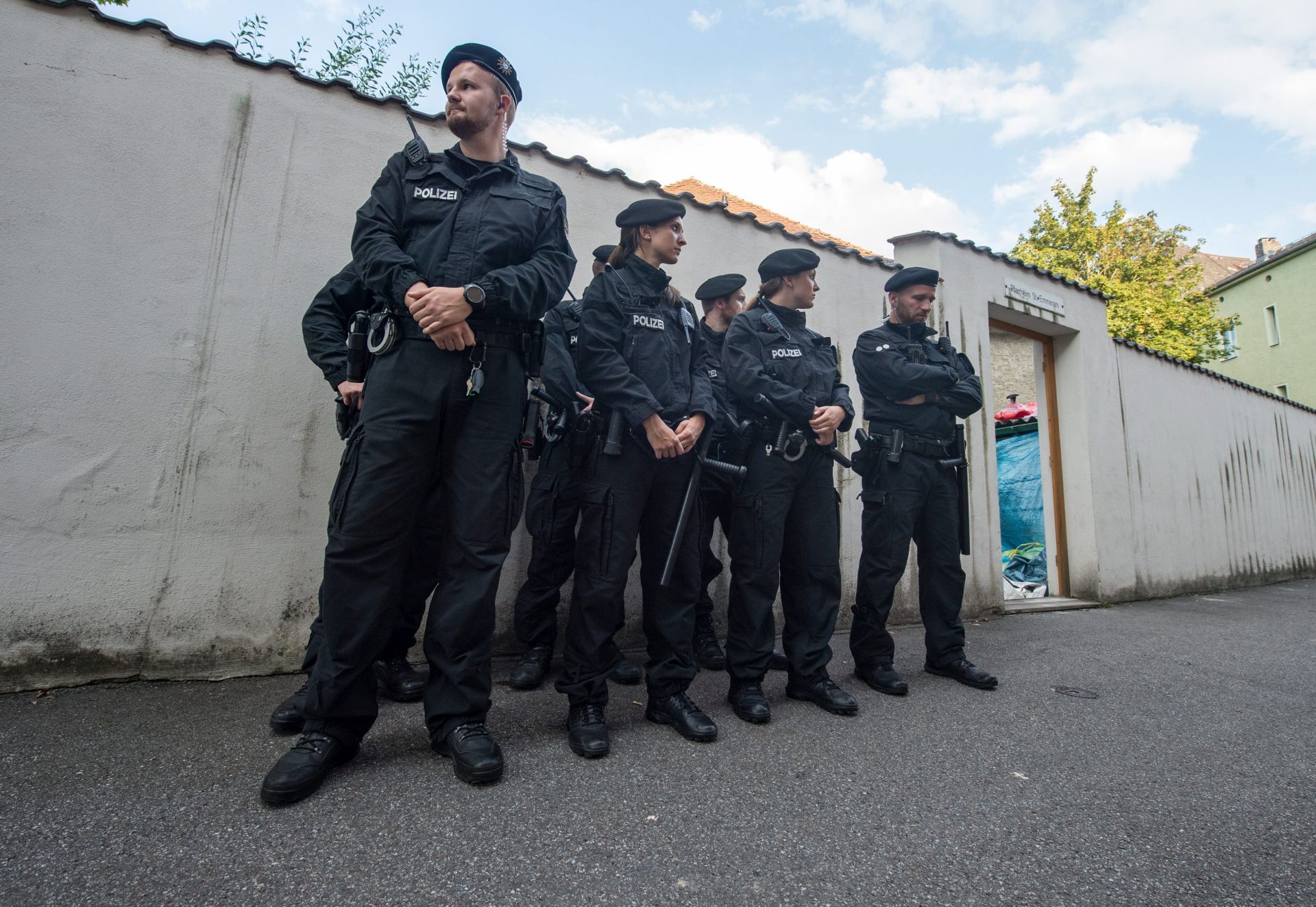 epa05465081 Police officers standing in front of the parish hall of St. Emmeram where refugees were living in Regensburg, Germany, 08 August 2016. For five weeks refugees have demonstrated with assistance from the Church for their right to stay - on Monday the parish hall has been cleared out by the police.  EPA/ARMIN WEIGEL