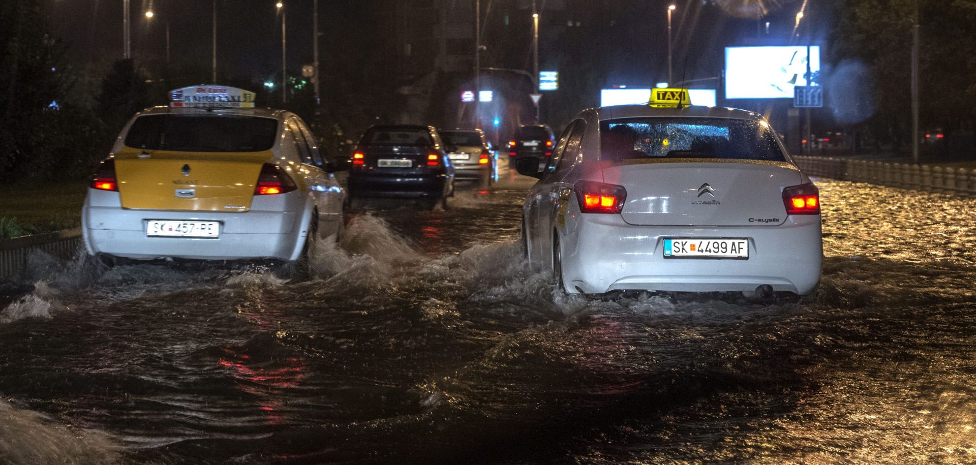 epa05460445 People drive their cars through a flooded street in the capitol Skopje, The Former Yugoslav Republic of Macedonia (FYROM), 06 August 2016. According to local reports, the thunderstorm hit the Skopje region with more than 800 strong electric discharges and with strong winds and intense raining.  EPA/GEORGI LICOVSKI