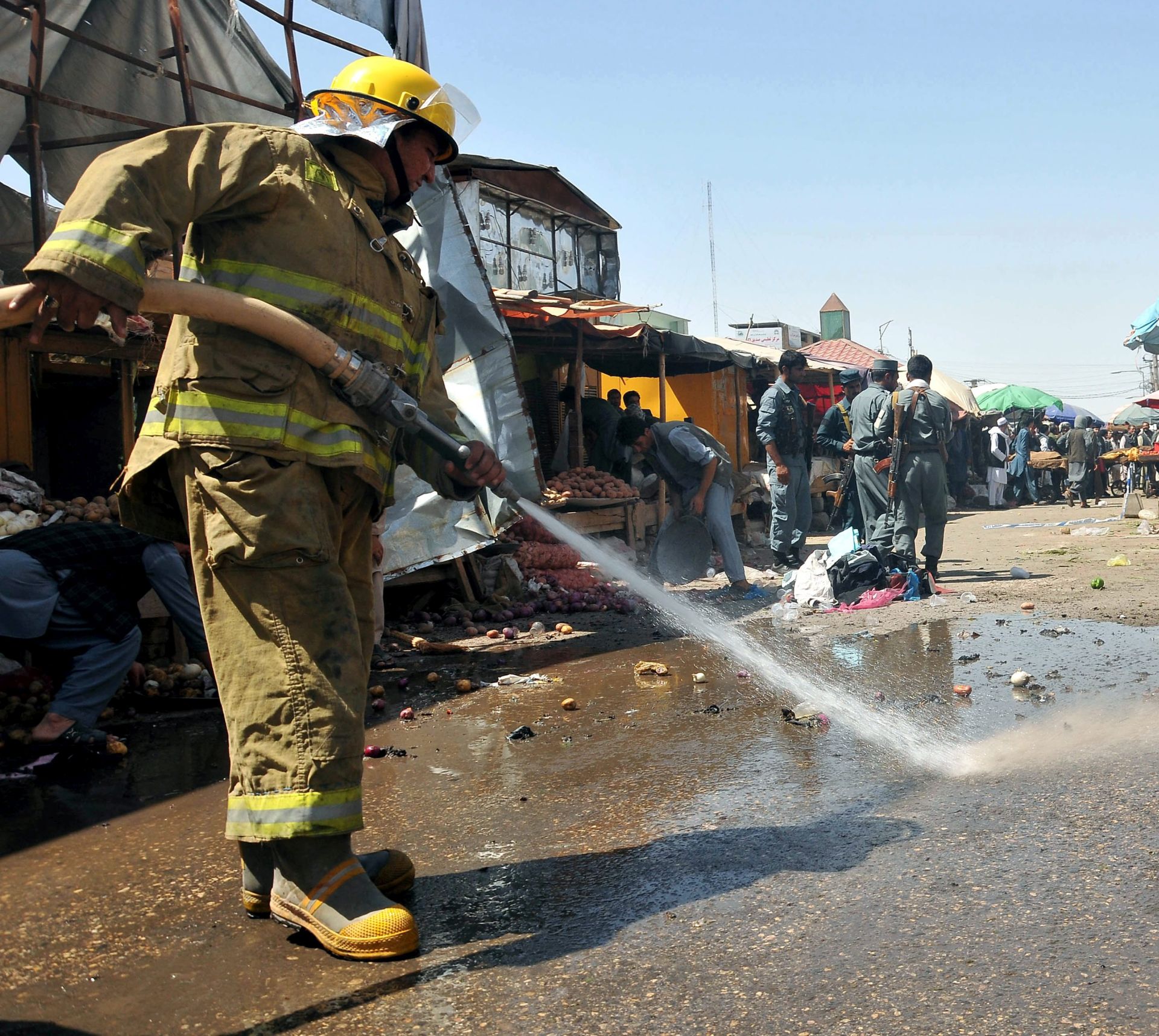 epa05467287 Members of the Afghan fire service wash down the scene of a suicide bomb blast in a busy market, in Mazar-i-Sharif, Afghanistan, 09 August 2016. According to media reports three people were killed in the bomb blast on a local market in Mazar-i-Sharif.  EPA/SAYED MUSTAFA