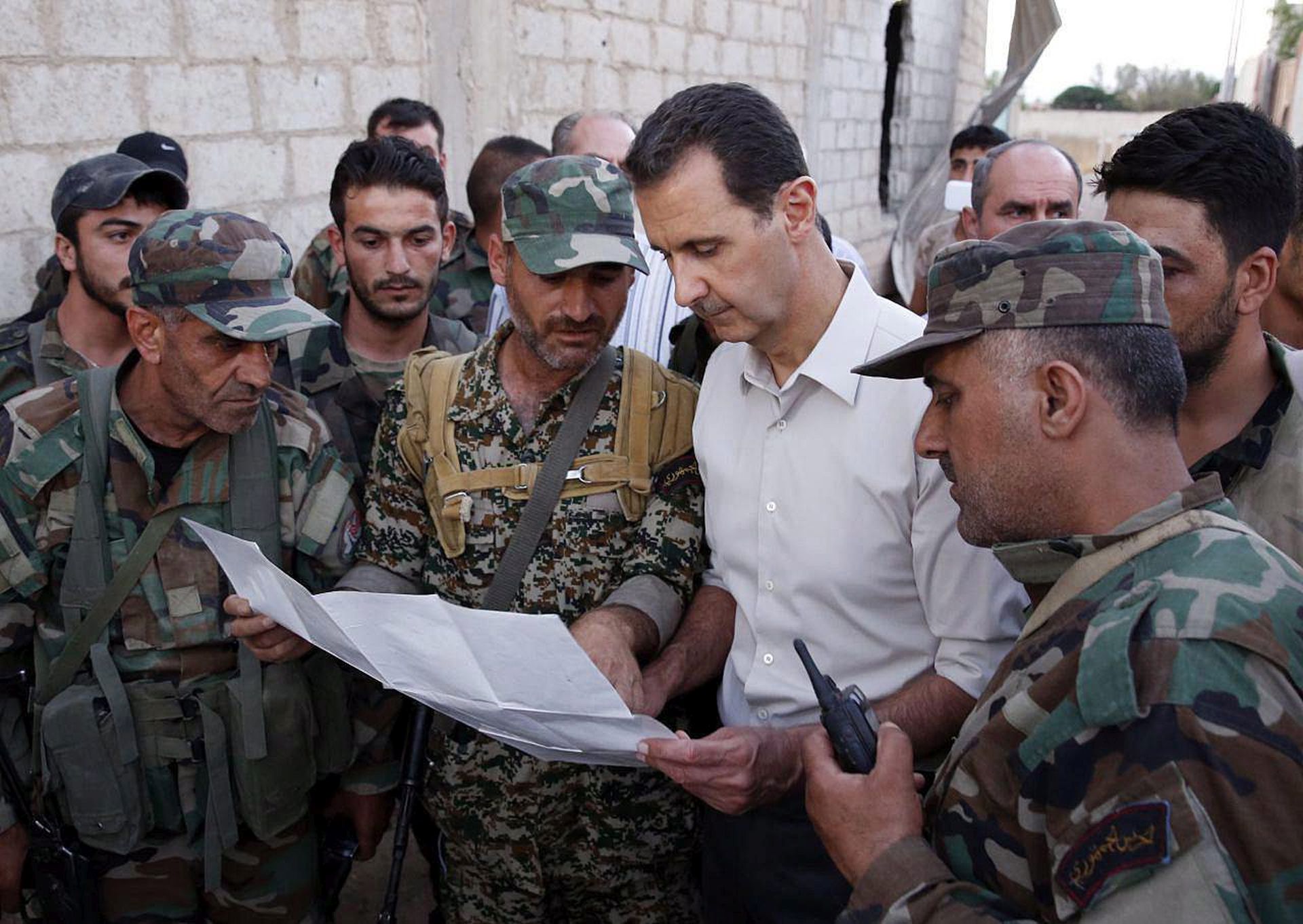 epa05394246 A handout picture made available on 27 June 2016 by Syrian Arab news agency (SANA) shows Syrian President Bashar al-Assad (C-R) meets with Syrian soldiers before he take his Iftar (break of fasting) of Ramadan along with members of the Syrian Arab army in Marj al-Sultan airport, Kharabou area, in Eastern Ghouta of Damascus countryside, Syria, 26 June 2016. Earlier President al-Assad wandered advanced points in the first array of Marj al-Sultan farms and the surrounding areas.  EPA/SANA / HANDOUT