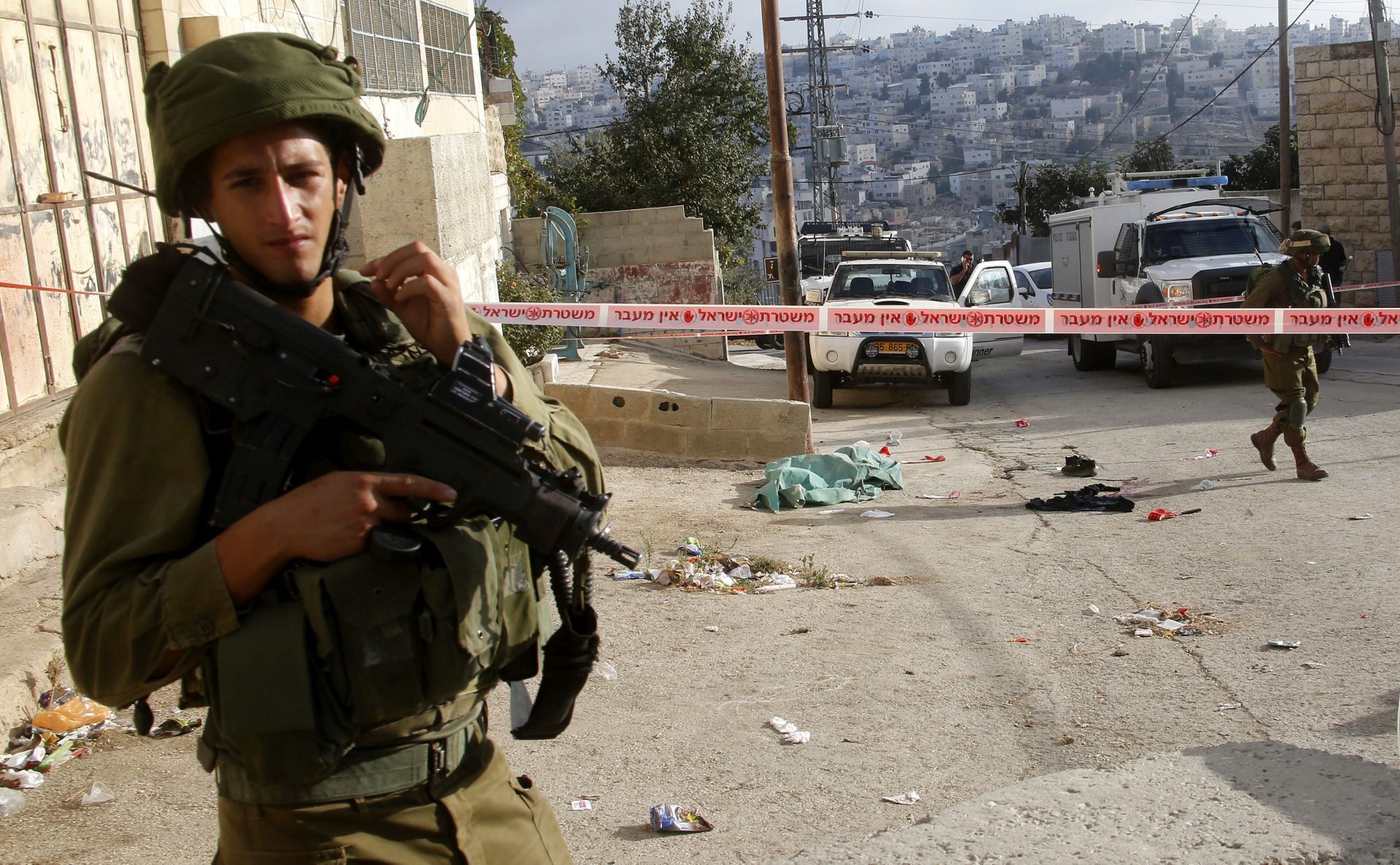 epa05543752 An armed Israeli army soldier stands guards near the sealed off scene of what the Israeli military said was a stabbing attack in Tal Rumaida, in the West Bank city of Hebron, 17 September 2016. Israeli military said a Palestinian assailant was shot dead after attacking a soldier with a knife.  EPA/ABED AL HASHLAMOUN