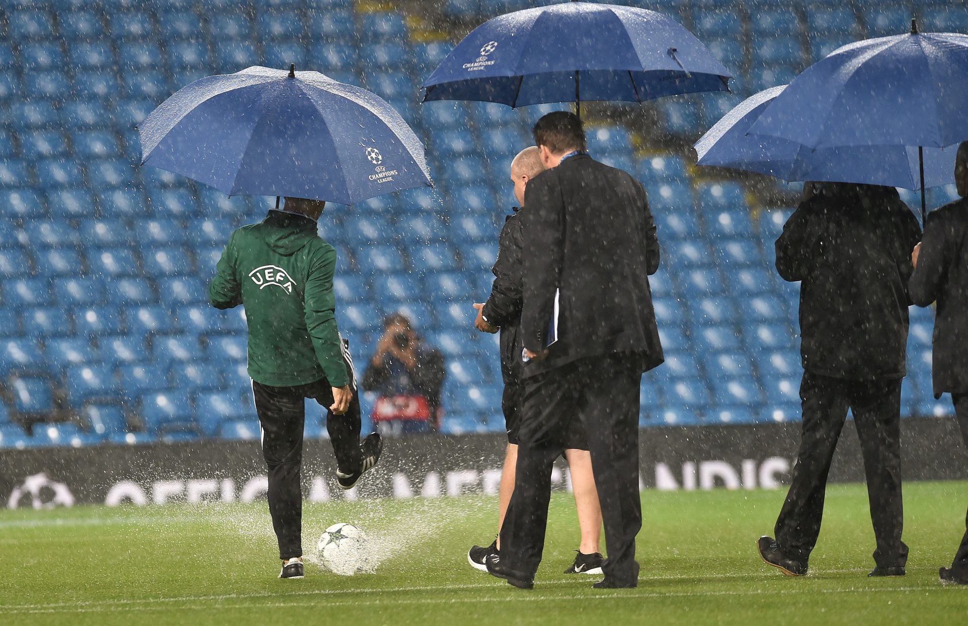epa05538190 An UEFA official kicks a ball on the pitch as heavy rain falls before the UEFA Champions League Group C match between Manchester City and Borussia Monchengladbach held at the Etihad Stadium in Manchester, Britain, 13 September 2016.  EPA/PETER POWELL