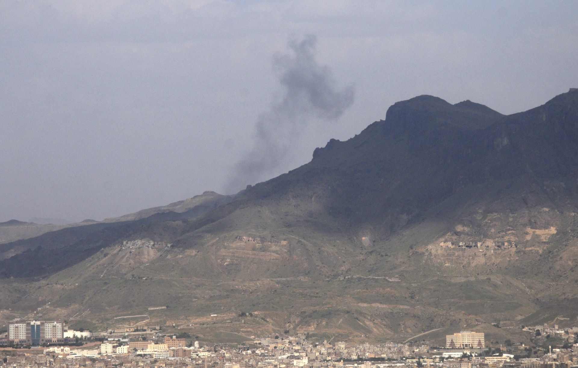 epa05513367 A picture made available on 28 August 2016 shows smoke drifting through the air from a Houthi-held weapon depot following airstrikes carried out by the Saudi-led coalition on a mountain overlooking Sanaa, Yemen, 27 August 2016. According to reports, the Saudi-led coalition continued to carry out airstrikes on Houthi positions in Yemen a few days after US Secretary of State John Kerry announced a new initiative to end the 18-month conflict in the troubled Arab country.  EPA/YAHYA ARHAB