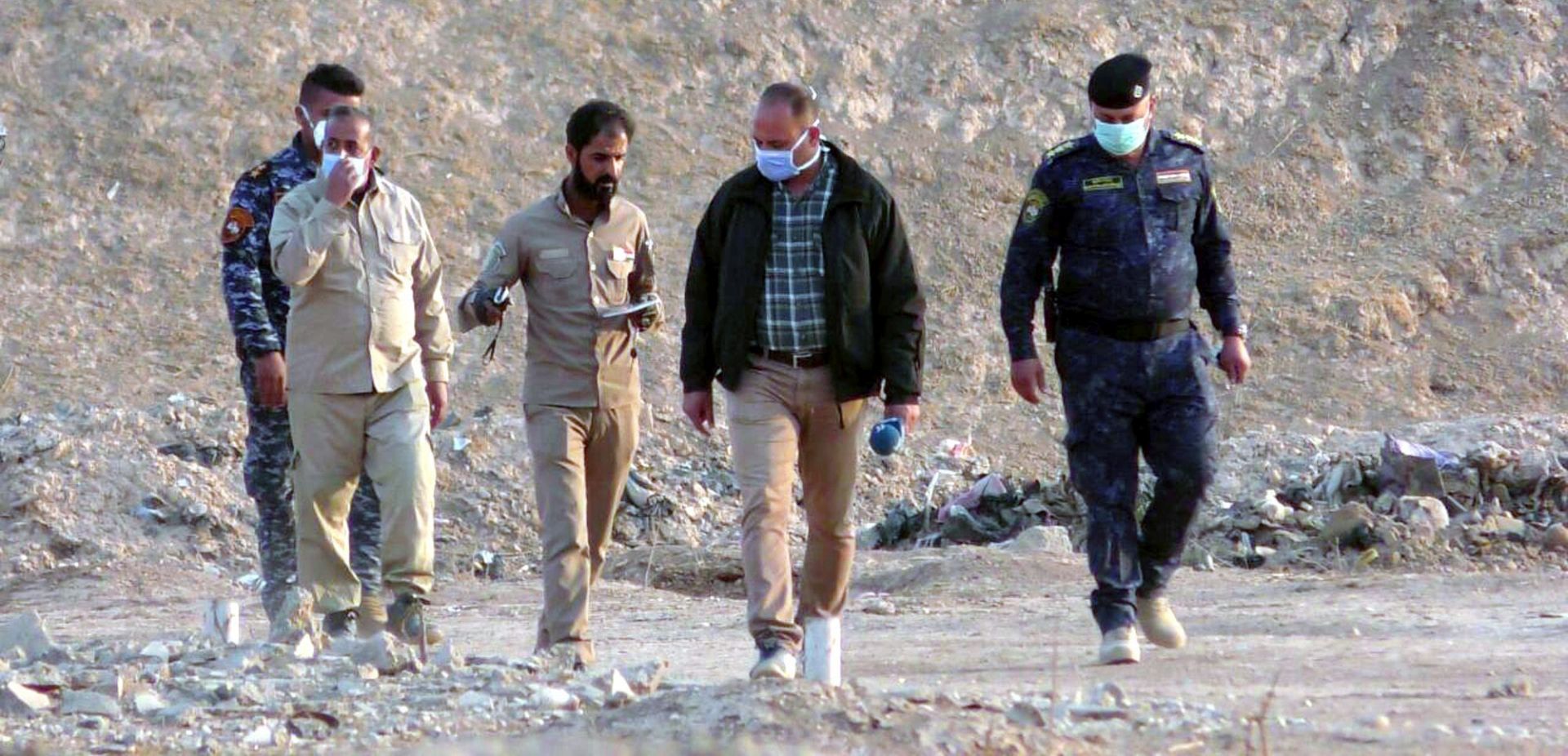 epa05622377 Iraqi officers and forensics personnel team inspect a site believed to be a mass grave, in Hamam al-Alil town, southern Mosul, Iraq, 08 November 2016. Reports state that Iraqi security officials found a mass grave in Hamam al-Alil town, containing some 100 bodies of people believed to be victims of the Islamic State (IS) militants, who were holding the town for more than two years ago.  EPA/STR