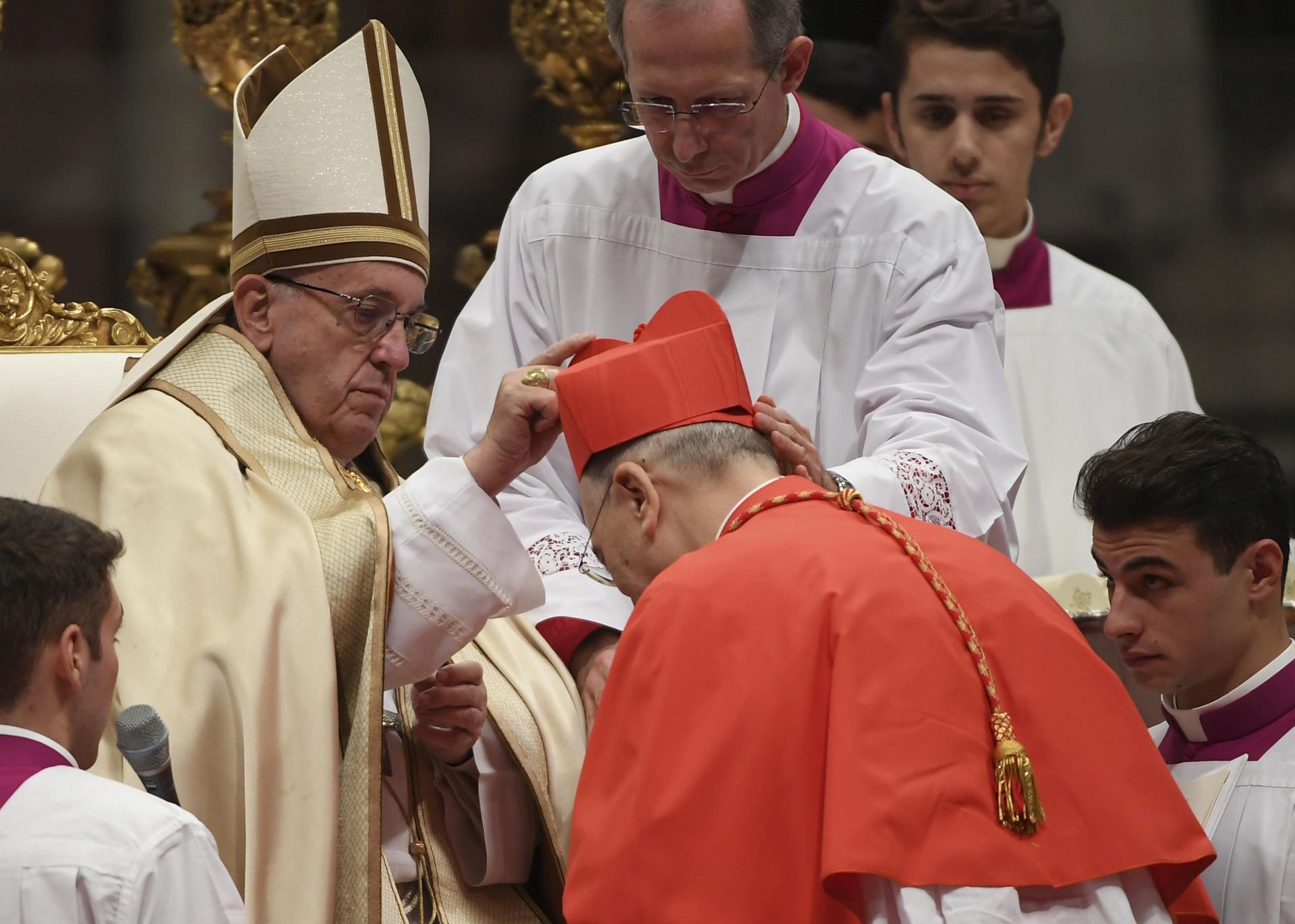 epa05637895 Pope Francis (L) places the red three-cornered biretta hat on the head of new Cardinal Carlos Osoro Sierra (R), Archbishop of Madrid, during the Consistory ceremony in Vatican, 19 November 2016. Pope Francis has named 17 new cardinals, 13 of them under age 80 and thus eligible to vote in a conclave to elect his successor.  EPA/MAURIZIO BRAMBATTI