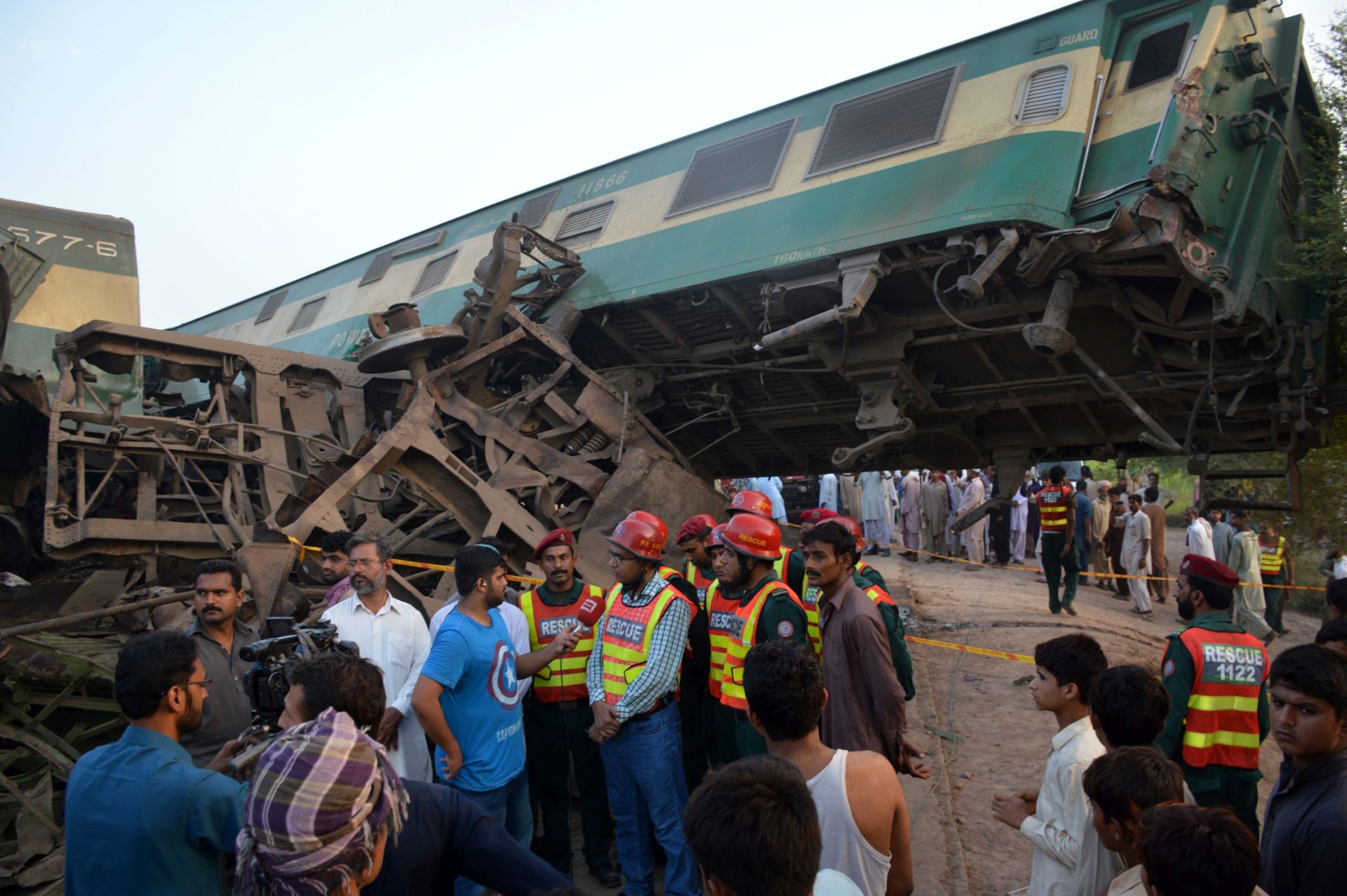 epa05540234 Rescue workers and people gather at the scene of a train accident near Buch station, close to Multan, Pakistan, 15 September 2016. A goods train collided with a Awam express passenger train near Multan, killing at least six passengers, according to authorities.  EPA/FAISAL KAREEM