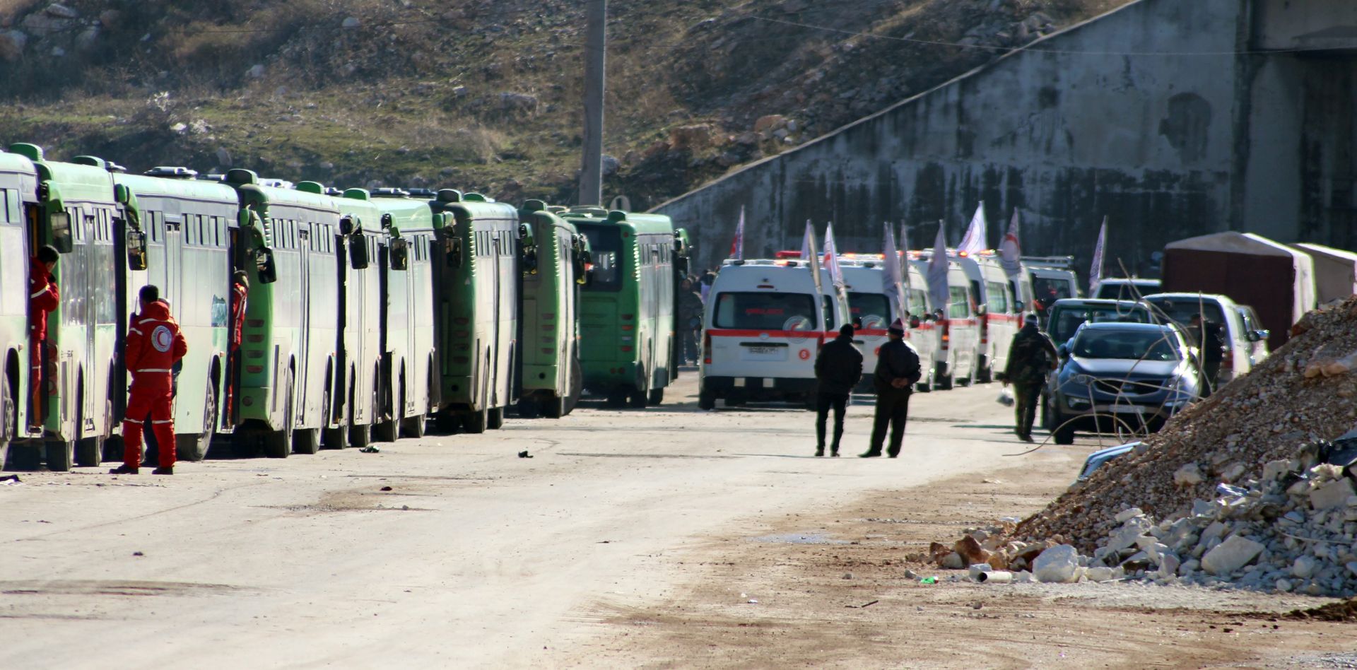 epa05677020 Busses and ambulances wait to evacuate fighters and their families from rebel-held zones in Aleppo, Syria, 15 December 2016. The evacuation of Aleppo began on 15 December as the first ambulances and buses extracted the sick and wounded from final rebel-held zones in the northern Syrian city, the Red Cross NGO said. Reports state the first batch of 951 gunmen and their families were evacuated via al-Ramouseh crossing to Aleppo southwestern countryside.  EPA/STR