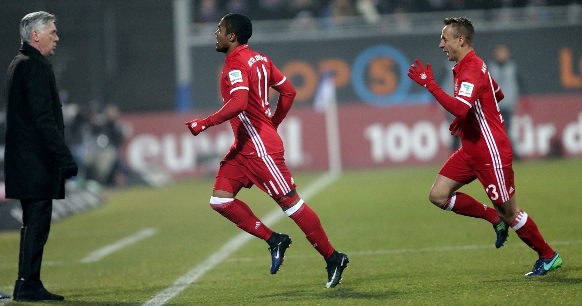 epa05681237 Munich's Douglas Costa (c) and Rafinha celebrate the 1:0 goal next to coach Carlo Ancelotti (l) during the Bundesliga soccer match between Darmstadt 98 and Bayern Munich at Jonathan Heimes stadium in Darmstadst, Germany, 18 December 2016.

(EMBARGO CONDITIONS - ATTENTION: Due to the accreditation guidlines, the DFL only permits the publication and utilisation of up to 15 pictures per match on the internet and in online media during the match.)  EPA/Hasan Bratic