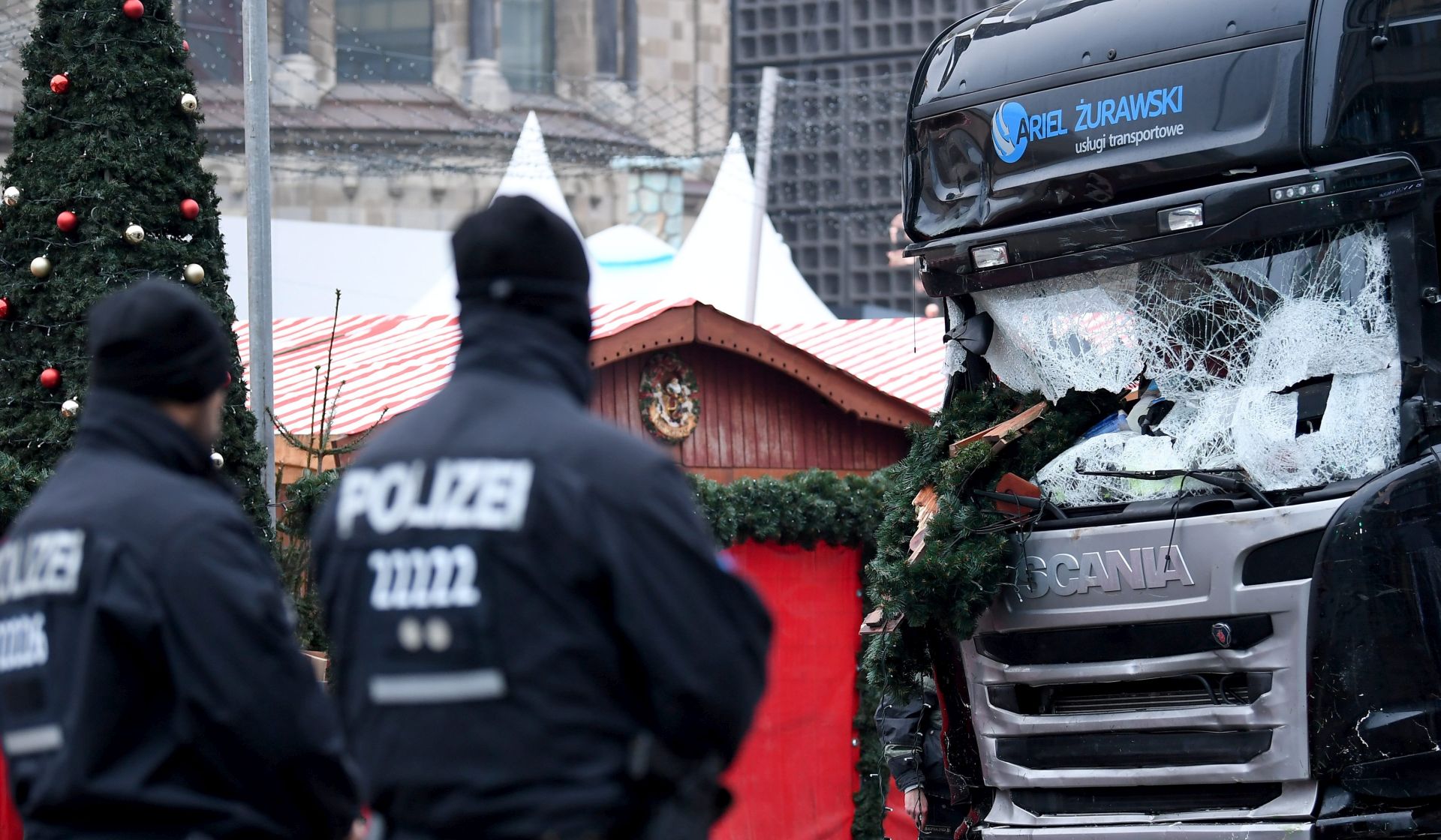 epa05683031 Police officers stand by a damaged truck at Breitscheidplatz in Berlin, Germany 20 December 2016. According to the police, at least 12 people were killed and at least 48 were injured after a truck ploughed into a busy Christmas market in Berlin. Authorities are investigating the incident as a 'possible terrorist attack,' media reported.  EPA/BRITTA PEDERSEN